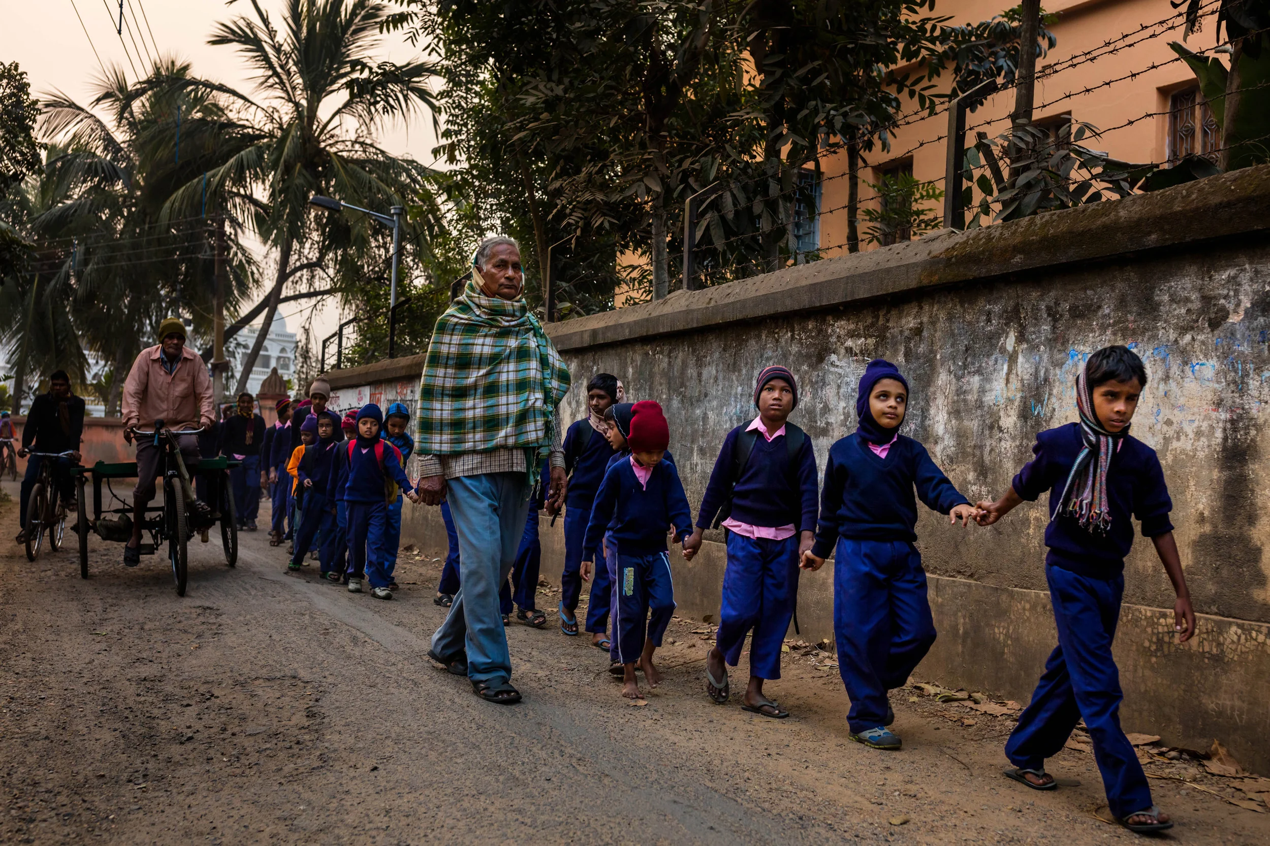 VIVEKANANDA MISSION ASRAM, HALDIA, WEST BENGAL, INDIA, JANUARY 17, 2016: Blind children make their way from the hostel residence of the Vivekananda Mission Asram school for the blind across a busy street on their way to school. This is the highest rated school for blind children in India, the country with the highest number of blind people, arond 1% of their population, approximately 12 million people. Vivekanda Mission Asram provides care to some of the poorest of blind children, providing them with an education and tools for life survival once they leave the Asram after graduating. The children learn a normal school curiculum through braile and a team of dedicated teachers. Vocationa training is also available at the Asram in weaving, candle making amongst other skills that can add meaning to a blind life in India. Most of the blind in India end up as beggars, this school offers students a chance to be more than that. A number of their students have gone on to become senior teachers for sighted pupils, lawyers and business people. In these images the boys and girls are seen attending school lessons, learning Braille, music as well as scenes from their hostel residence and sports activities. (Photo by Brent Stirton/Reportage for National Geographic Magazine.)