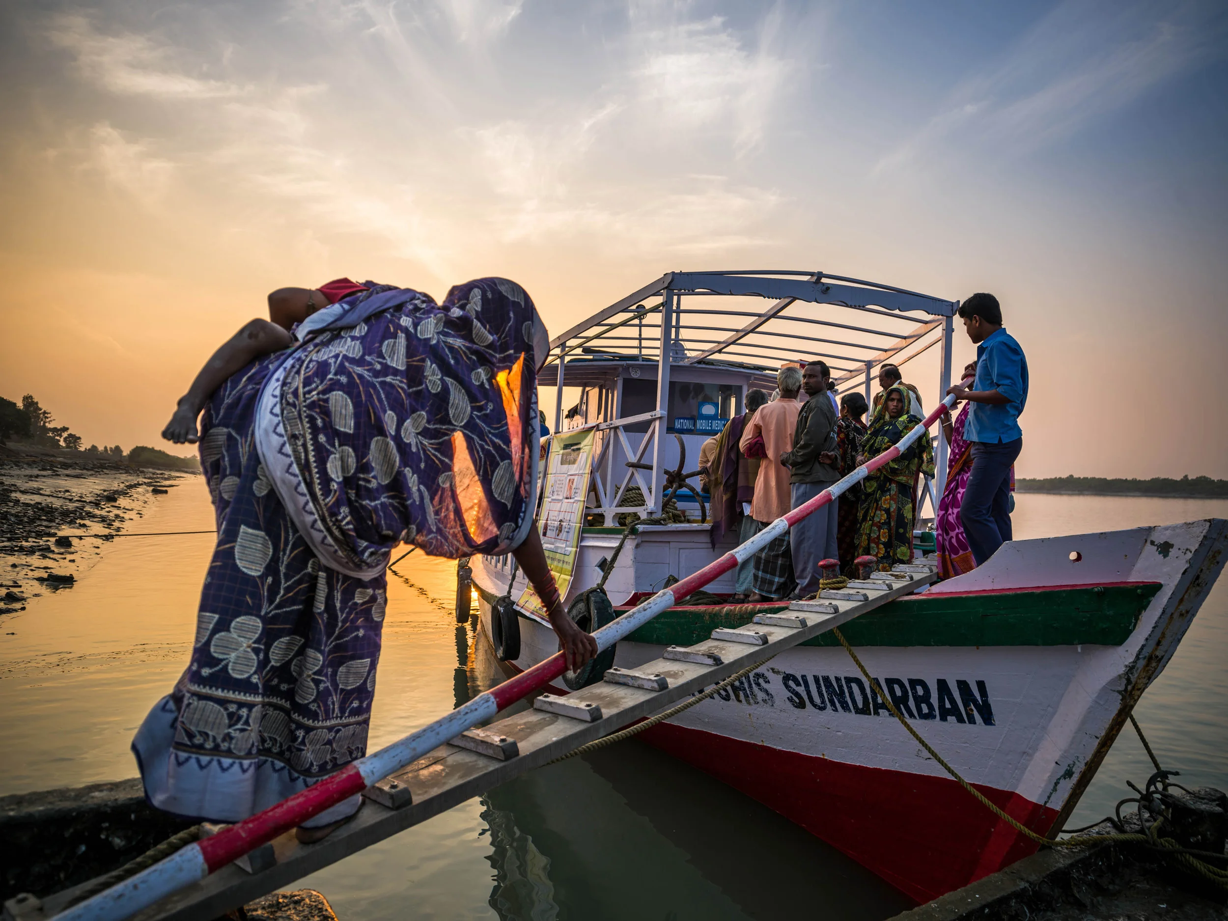 SUNDARBANS, INDIA: A blind woman with a child feels her way on to a boat that is a mobile camp for eye care in a remote part of the Sundarban islands in India. These boats offer general eye health diagnosis to extremely impoverished villages deep within the Sundarbans. Dr Asim Sil’s extremely dedicated team uses these boats to get around the Sundarbans and often works from early morning to late at night on patients who would otherwise have no access to good eye care. The goal of the team is to educate and offer refractive services, ie glasses; to diagnose eye health problems and to offer surgical solutions to patients who need them, including transport to the hospitals. These services are provided free of charge. Dr Sil has worked on eye care in the Sundarbans since 1989, and along with his team has been of service to thousands of patients in this remote region of India. A high povery index and remoteness of location coupled with a lack of access to quality eye care has seen India become the country with the highest number of blind people. Most of these cases began as problems that if diagnosed earlier, could have been prevented.