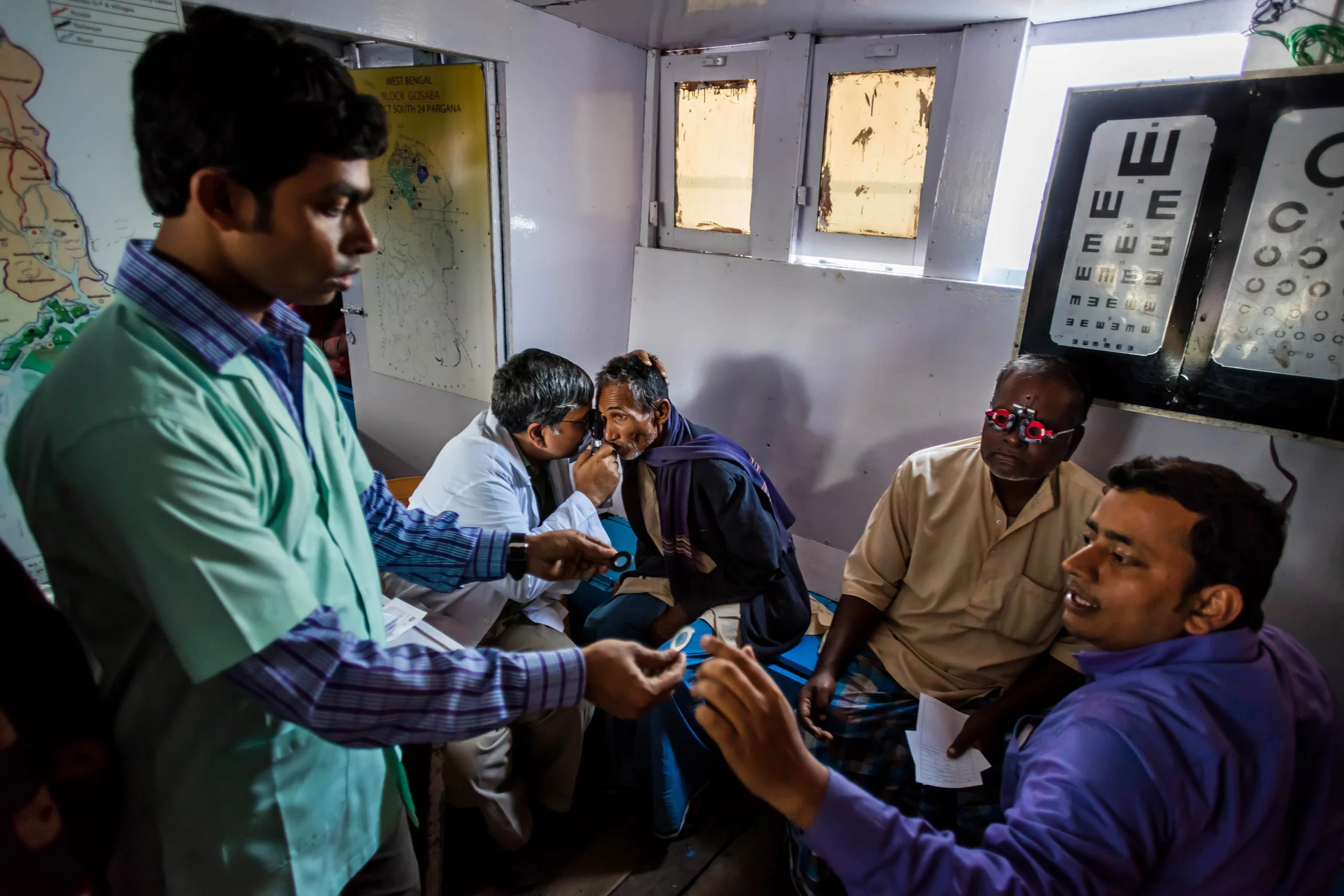 Sundarbans, India, 11 January 2016: Dr Asim Sil leads a team of eye care specialists on a boat-camp for eye care in a remote part of the Sundarbans, India. These boats are often used in partnership with other NGO’s, offering general healthcare facilities as well as eye health diagnosis to extremely impoverished villages deep within the Sundarbans. Dr Sil’s team uses boats to get around the Sundarbans and often works from early morning to late at night on patients who would otherwise not have access to good eye care. The goal of the team is to educate and offer refractive services, ie glasses; to diagnose eye health problems and to offer surgical solutions to patients who need them, including transport to the hospitals. These services are provided free of charge by Vivekananda Mission Asram hospital. Dr Sil has worked on eye care in the Sundarbans since 1989, and along with his team has been of service to thousands of patients in this remote region of India. A high povery index and remoteness of location coupled with a lack of access to quality eye care has seen India become the country with the highest number of blind people. Most of these cases began as problems that if diagnosed earlier, could have been prevented. (Photo by Brent Stirton/Reportage for National Geographic Magazine.)