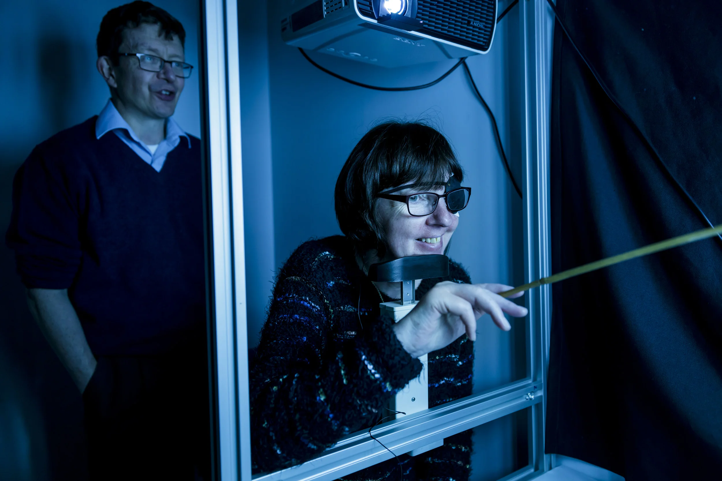 OXFORD EYE HOSPITAL, OXFORDSHIRE, ENGLAND, 23 FEBRUARY 2016: Rhian Lewis, 50, is the first patient in the UK to receive the world’s most advanced “bionic eye.” Surgeons at the Oxford Eye Hospital at Oxford’s John Radcliffe Hospital implanted a tiny electronic chip at the back of Rhian’s retina in her right eye as part of ongoing research of the technology. Mother-of-two Rhian, of Cardiff, Wales, was diagnosed with Retinitis Pigmentosa – a disorder that destroys the light sensitive cells called photoreceptors in the retina – when she was five. She is completely blind in her right eye and has virtually no vision in her left eye as a result of the condition, for which there is no cure.But behind the destroyed photoreceptors she still had an intact optic nerve and all the brain wiring needed for vision, making it possible to restore vision if only a way could be found to substitute the function of the photoreceptors.The wafer-thin retinal implant chip – which measures 3x3mm² - is inserted into the back of the eye to replace damaged photoreceptors in a delicate six to eight hour operation. The chip has been developed by German engineering firm Retina Implant AG and captures the light entering the eye to stimulate the nerve cells of the inner retina to deliver signals to the brain through the optic nerve.The device is connected to a tiny computer that sits underneath the skin behind the ear. A magnetic coil that is applied to the skin powers this – from the outside this looks similar to a hearing aid. The device is switched on once everything has healed after surgery. It takes time for users to learn to interpret the sight the implant provides, as, for most of the trial patients, the parts of the brain responsible for interpreting vision have been dormant for a long time. When the device is first switched on they will often see flashes of light, but over a few weeks the brain converts those flashes into meaningful shapes and objects to build up an imag