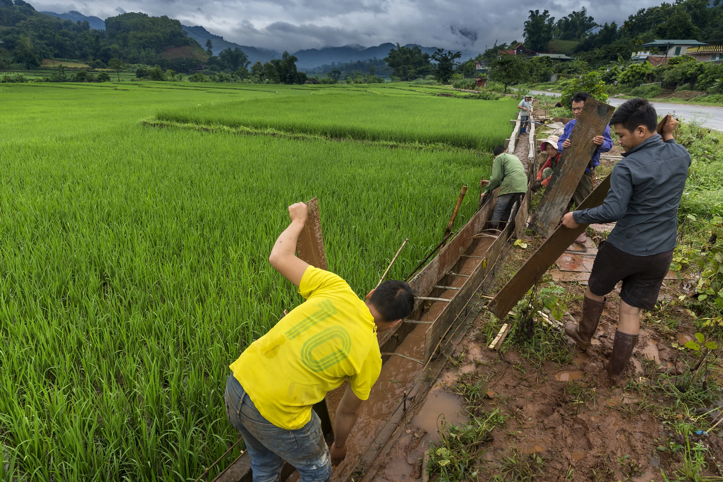 SON LA, VIETNAM, 20 AUGUST 2016: Men from a farming hamlet in Son La province construct an irrigation system for their rice paddies. Most of these farmers will eat the rice they produce, using the proceeds from corn they raise for animal feed to purchase it. (Photo by Brent Stirton/Reportage by Getty Images.)