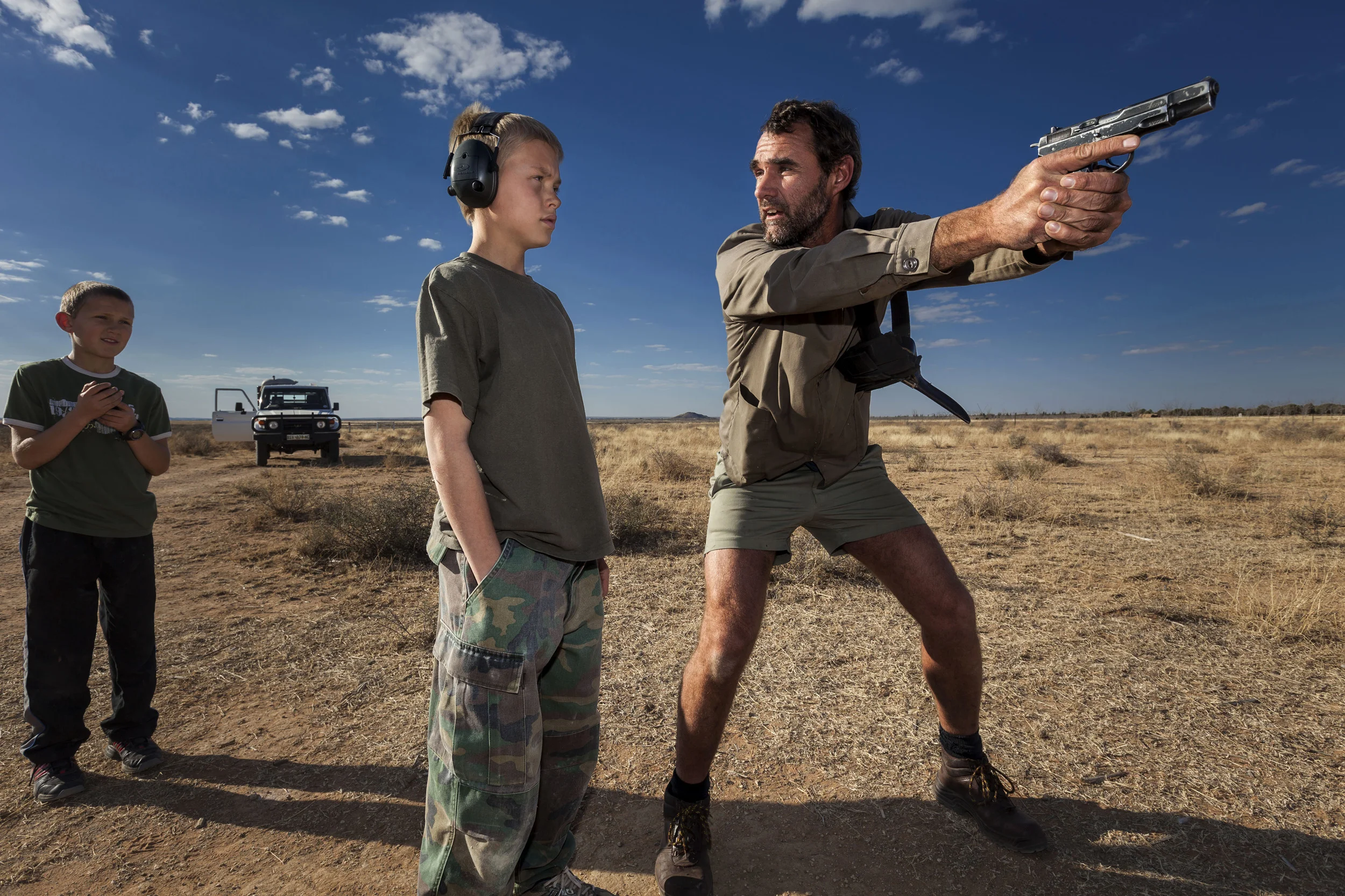 ORANIA, NORTH WEST CAPE PROVINCE, SOUTH AFRICA: Niklas Kirsten, an Orania resident and former South African Army Paratrooper, teaches Erik Du Pree hand-gun self-defence in the fields outside Orania, South Africa. Orania is a privately owned South African town located along the Orange River in the Northern Cape Province. Orania is a former government workers village originally bought by a group of Afrikaners in 1991 from the South African government with the intention of creating a pure Afrikaner community which functions as a stronghold for conservative Afrikaner cultural and religious values. Orainia currently has four times more applicants than they can handle, one of the drivers for this is the farm attacks phenomenon which currently see White South African farmers as the most vulnerable population group in the world. Increasing anti-white hate speech from the black right wing is only driving this further. The Orania community sees themselves as independant from the rest of South Africa with a goal of a self-determining Afrikaner homeland. All work in Orania is done by white Afrikaners. They do not see themselves as right wing, but are very concerned with their ultra conservative cultural and religious integrity and independence. They welcome anyone who shares those values and as a result are one hundred percent white in ethnicity. THere has been a steady rise in population numbers for Orania, due to ongoing disenfranchisement of white South Africans as a result of Black Empowerment policies of the ANC government as well as undiminished, traumatically high crime statistics which are driving whites to seek shelter in perceived safer communities such as Orania. There has also been a solid increase in the numbers of professional people moving to Orania in the face of the afore mentioned drivers. Up until now there have been good relations between Orania and the SA government and in June 1998 the then Minister of Constitutional Development in the ANC governement sta