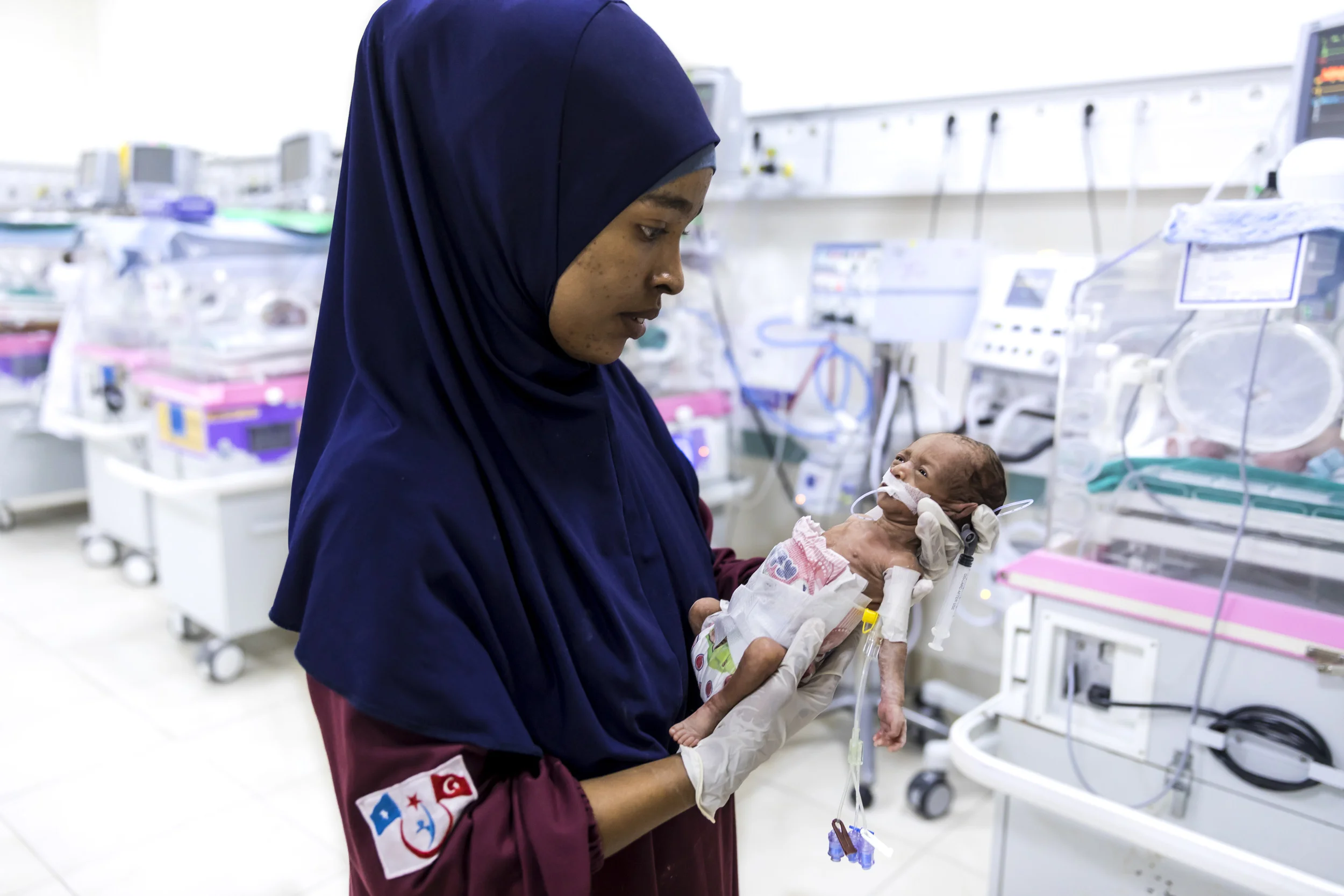 MOGADISHU, SOMALIA, 3 AUGUST 2017: Nurses attend premature babies inside the new neo-natal unit at the Turkish built and run hospital in Mogadishu. The child in this image weighed only 600 grams at birth and would surely have died without this special unit. The hospital has 16 incubators for premature babies, the only facility of its kind in Somalia. There has been increasing relations between the Turks and the Somalis, with the Turks building not only this hospital but also the new airport and many other projects in Mogadishu. President Erdogan himself has visited and opened the new hospital. The Turkish embassy in Mogadishu is huge and reaffirms their long-term commitment to investing in Somalia. (Photo by Brent Stirton/Verbatim for Time Magazine.)