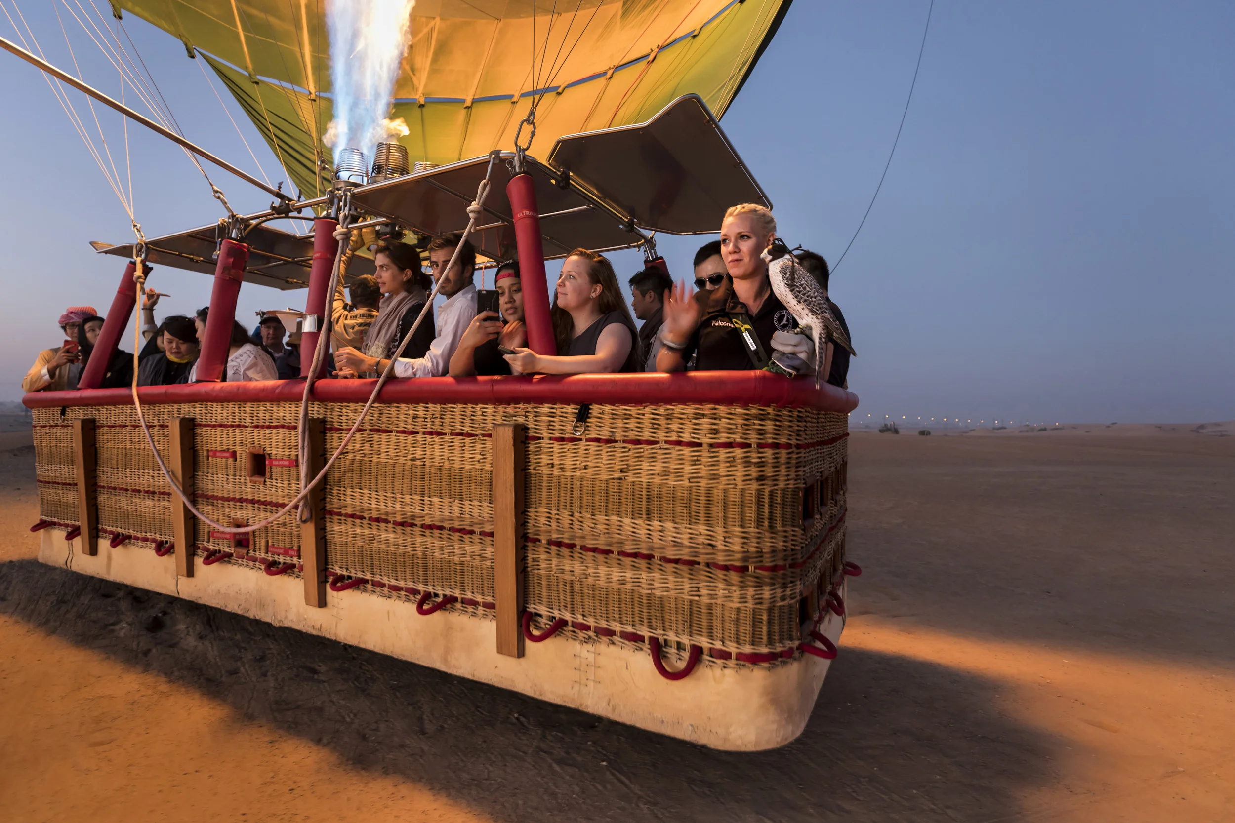 DUBAI, UAE, 26 September, 2017: Tourist balloons take off in the desert outside of Dubai. Inside the basket are two falconers from Royal Shaheen Falconry who will entertain the crowd with falconry at height over the desert. (Photo by Brent Stirton/Verbatim for National Geographic Magazine.)