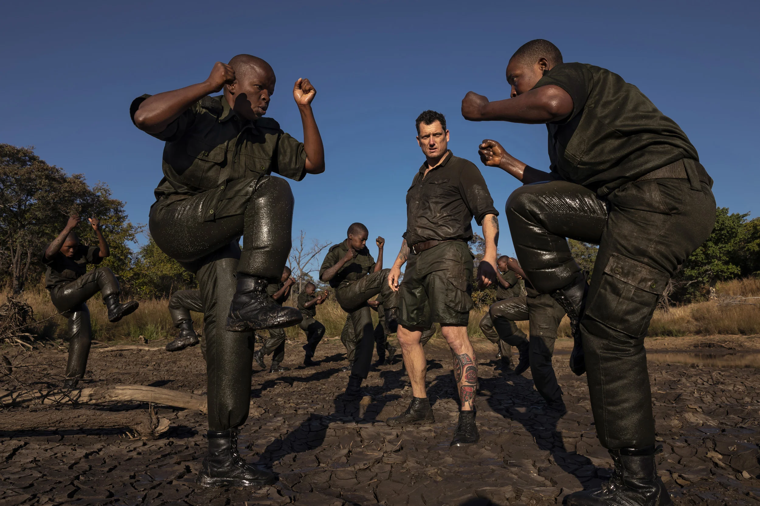PHUNDUNDU WILDLIFE AREA, ZIMBABWE, JUNE 2018: Members of the all female conservation ranger force known as Akashinga undergo tough training in the bush near their base. Akashinga (meaning the ‘Brave Ones’ in local dialect) is a community-driven conservation model, empowering disadvantaged women to restore and manage a network of wilderness areas as an alternative to trophy hunting. Many current western-conceived solutions to conserve wilderness areas struggle to gain traction across the African continent. Predominately male forces are hampered by ongoing corruption, nepotism, drunkenness, aggressiveness towards local communities and a sense of entitlement. The I.A.P.F, the International Anti-Poaching Foundation led by former Australian Special Forces soldier Damien Mander, was created as a direct action conservation organisation to be used as a surgical instrument in targeting wildlife crime. In 2017 they decided to innovate, using an all- female team to manage an entire nature reserve in Zimbabwe. The program builds an alternative approach to the militarized paradigm of ‘fortress conservation’ which defends colonial boundaries between nature and humans. While still trained to deal with any situation they may face, the team has a community-driven interpersonal focus, working with rather than against the local population for the long-term benefits of their own communities and nature. Cut off from places of worship and burial, grazing areas, access to water, food, traditional medicine and given limited opportunity for employment or tourism benefits, it’s little wonder many of these communities struggle to see any value in conservation efforts.
Women have traditionally played major roles in battle and are now re-emerging as key solutions in law enforcement and conflict resolution. In the Middle-East, counterinsurgency operations that involve penetrating and working with the local population to try and win the hearts and minds have become fundamentally relian