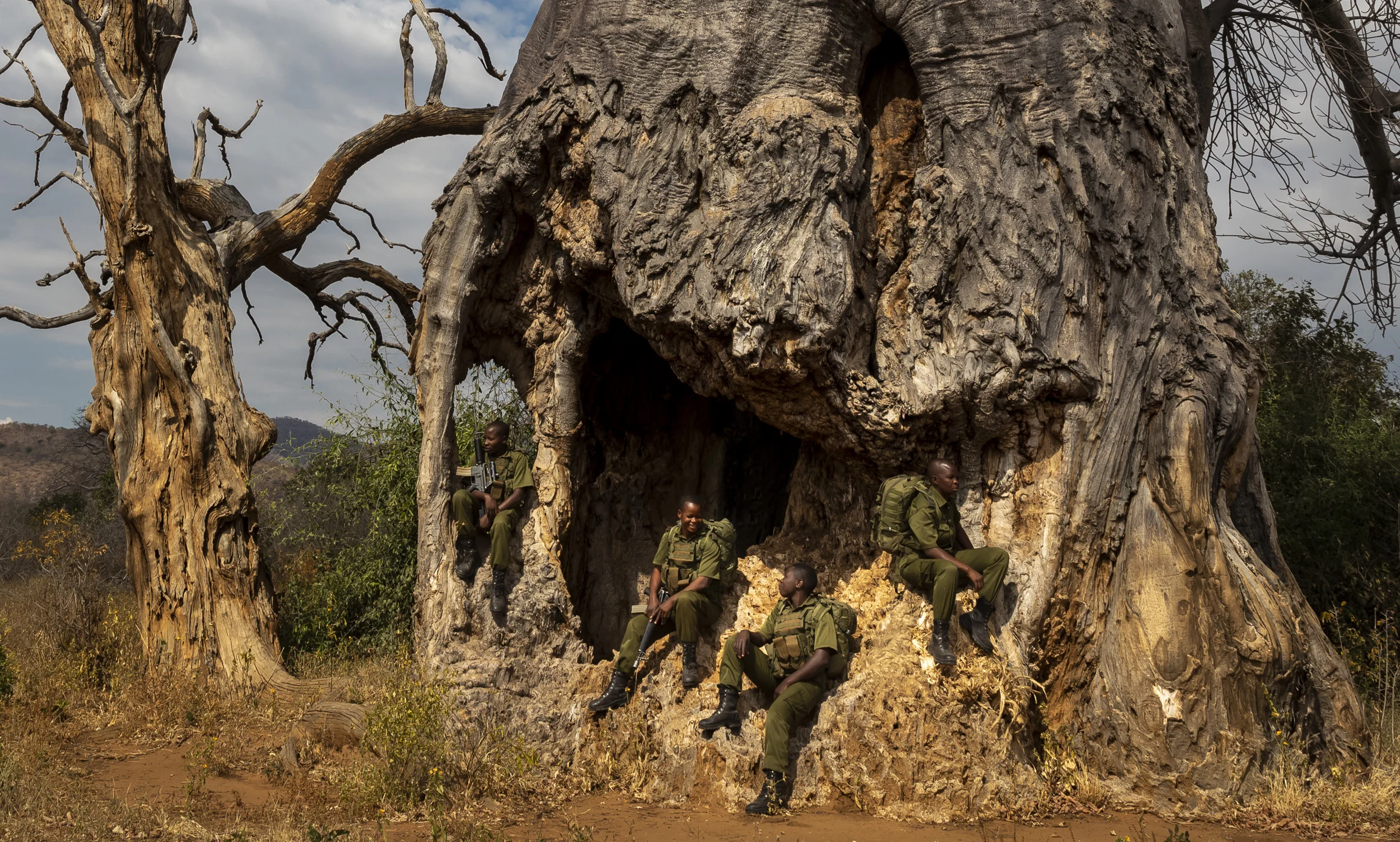 PHUNDUNDU WILDLIFE AREA, ZIMBABWE, JUNE 2018: Akashinga (meaning the ‘Brave Ones’ in local dialect) is a community-driven conservation model, empowering disadvantaged women to restore and manage a network of wilderness areas as an alternative to trophy hunting. Here some of these women are seen interacting with elephant and out on patrol. Many current western-conceived solutions to conserve wilderness areas struggle to gain traction across the African continent. Predominately male forces are hampered by ongoing corruption, nepotism, drunkenness, aggressiveness towards local communities and a sense of entitlement. The I.A.P.F, the International Anti-Poaching Foundation led by former Australian Special Forces soldier Damien Mander, was created as a direct action conservation organisation to be used as a surgical instrument in targeting wildlife crime. In 2017 they decided to innovate, using an all- female team to manage an entire nature reserve in Zimbabwe. The program builds an alternative approach to the militarized paradigm of ‘fortress conservation’ which defends colonial boundaries between nature and humans. While still trained to deal with any situation they may face, the team has a community-driven interpersonal focus, working with rather than against the local population for the long-term benefits of their own communities and nature. Cut off from places of worship and burial, grazing areas, access to water, food, traditional medicine and given limited opportunity for employment or tourism benefits, it’s little wonder many of these communities struggle to see any value in conservation efforts.
Women have traditionally played major roles in battle and are now re-emerging as key solutions in law enforcement and conflict resolution. In the Middle-East, counterinsurgency operations that involve penetrating and working with the local population to try and win the hearts and minds have become fundamentally reliant on the nature, credibility and intuition o