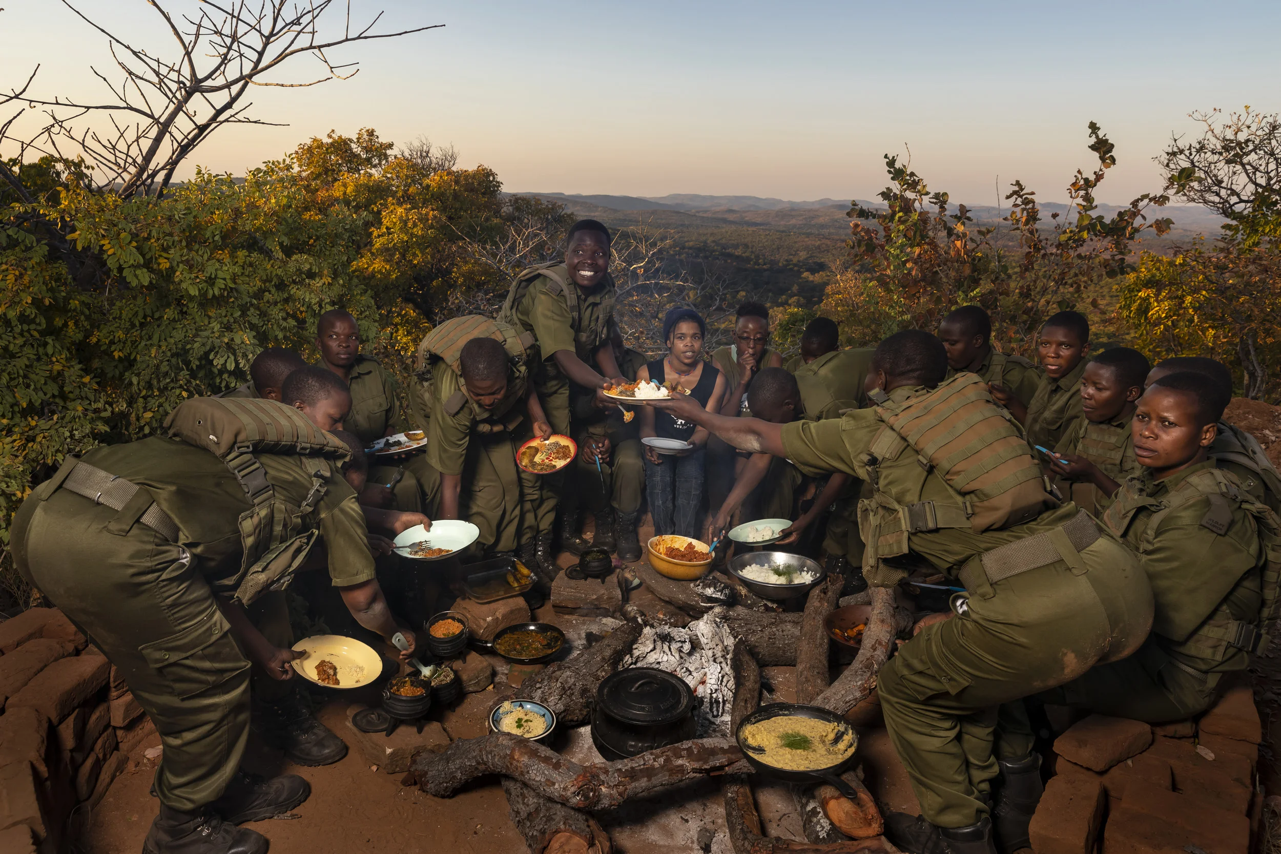 PHUNDUNDU WILDLIFE AREA, ZIMBABWE, JUNE 2018: The female Akashinga members voluntarily all became vegans to demonstrate their commitment to all forms of life on the planet. They are seen being served vegan meals by vegan chefs who have come from South Africa to teach the rangers about vegan cooking. Many current western-conceived solutions to conserve wilderness areas struggle to gain traction across the African continent. Predominately male forces are hampered by ongoing corruption, nepotism, drunkenness, aggressiveness towards local communities and a sense of entitlement. The I.A.P.F, the International Anti-Poaching Foundation led by former Australian Special Forces soldier Damien Mander, was created as a direct action conservation organisation to be used as a surgical instrument in targeting wildlife crime. In 2017 they decided to innovate, using an all- female team to manage an entire nature reserve in Zimbabwe. The program builds an alternative approach to the militarized paradigm of ‘fortress conservation’ which defends colonial boundaries between nature and humans. While still trained to deal with any situation they may face, the team has a community-driven interpersonal focus, working with rather than against the local population for the long-term benefits of their own communities and nature.
