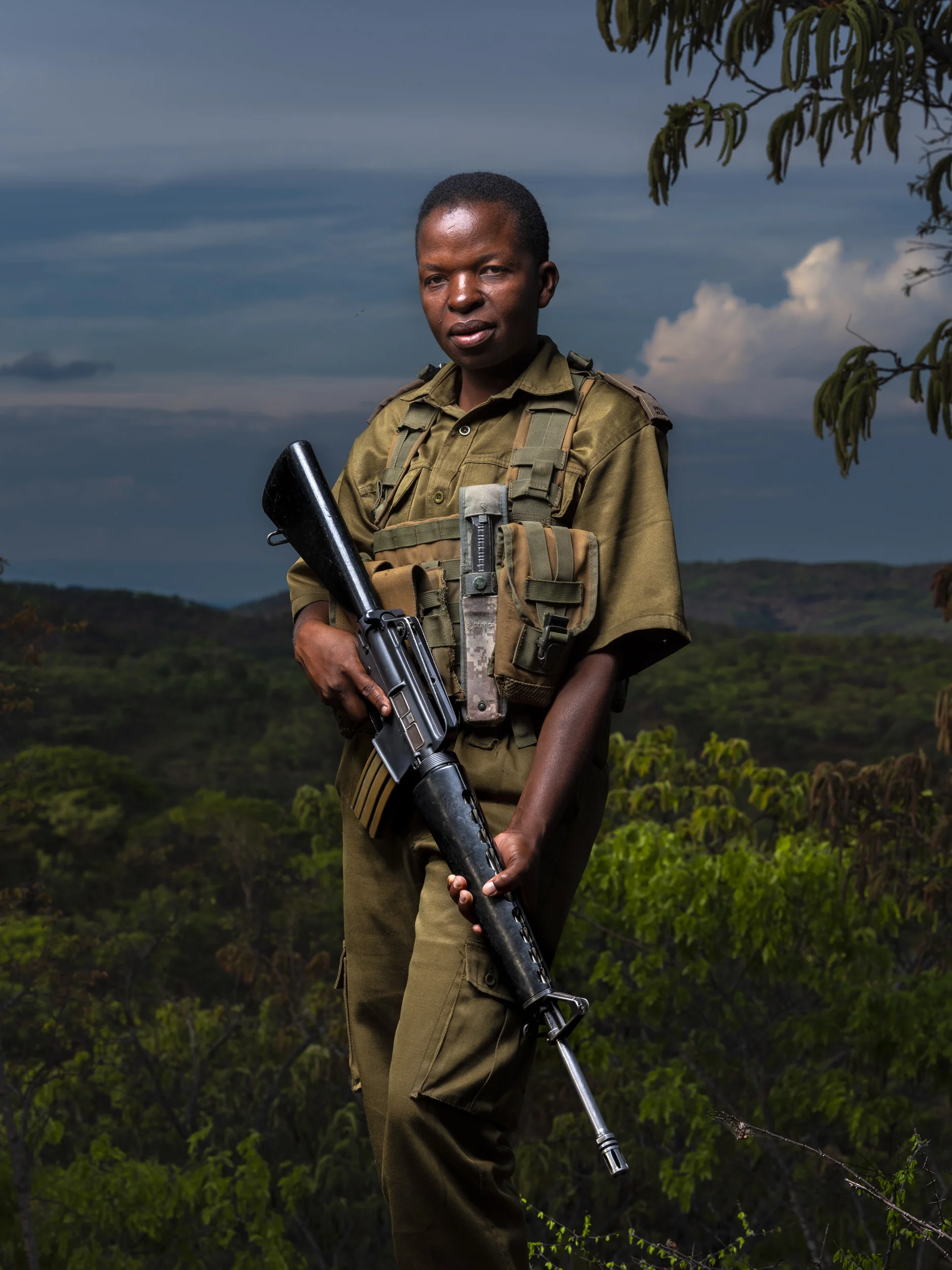 PHUNDUNDU WILDLIFE AREA, ZIMBABWE, DECEMBER 2018: Sergeant Vimbai is seen as a role model in her community. Through her conservation work she has distanced herself from an extremely abusive marriage and is now able to pay school fees for her children despite coming from the poorest demographic in Zimbabwe. She is part of an all female conservation ranger force known as “Akashinga” Akashinga (meaning the ‘Brave Ones’) is a community-driven conservation model, empowering disadvantaged women to restore and manage a network of wilderness areas as an alternative to trophy hunting in Zimbabwe. Predominately male forces are often hampered by ongoing corruption, nepotism, drunkenness, aggressiveness towards local communities and a sense of entitlement. The International Anti-Poaching Foundation, led by former Australian Special Forces soldier Damien Mander, was created as a direct action conservation organization used as a surgical instrument in targeting wildlife crime. In 2017 they decided to innovate, using an all- female team to manage an entire nature reserve in Zimbabwe. The program builds an alternative approach to the militarized paradigm of ‘fortress conservation’ that defends colonial boundaries between nature and humans. While still trained to deal with any situation they may face, the team has a community-driven interpersonal focus, working with rather than against the local population for the long-term benefits of their own communities and nature.
