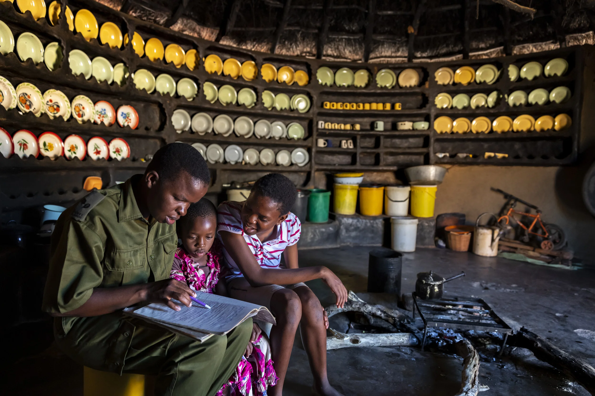 PHUNDUNDU WILDLIFE AREA, ZIMBABWE, DECEMBER 2018: Sergeant Vimbai Kamire comes home from the bush to visit her two daughters during her time off. Sergeant Vimbai is seen as a role model in her community. Through her conservation work she has distanced herself from an extremely abusive marriage and is now able to pay school fees for her children despite coming from the poorest demographic in Zimbabwe. She is part of an all female conservation ranger force known as “Akashinga” Akashinga (meaning the ‘Brave Ones’) is a community-driven conservation model, empowering disadvantaged women to restore and manage a network of wilderness areas as an alternative to trophy hunting in Zimbabwe. Predominately male forces are often hampered by ongoing corruption, nepotism, drunkenness, aggressiveness towards local communities and a sense of entitlement. The International Anti-Poaching Foundation, led by former Australian Special Forces soldier Damien Mander, was created as a direct action conservation organization used as a surgical instrument in targeting wildlife crime. In 2017 they decided to innovate, using an all- female team to manage an entire nature reserve in Zimbabwe. The program builds an alternative approach to the militarized paradigm of ‘fortress conservation’ that defends colonial boundaries between nature and humans. While still trained to deal with any situation they may face, the team has a community-driven interpersonal focus, working with rather than against the local population for the long-term benefits of their own communities and nature.