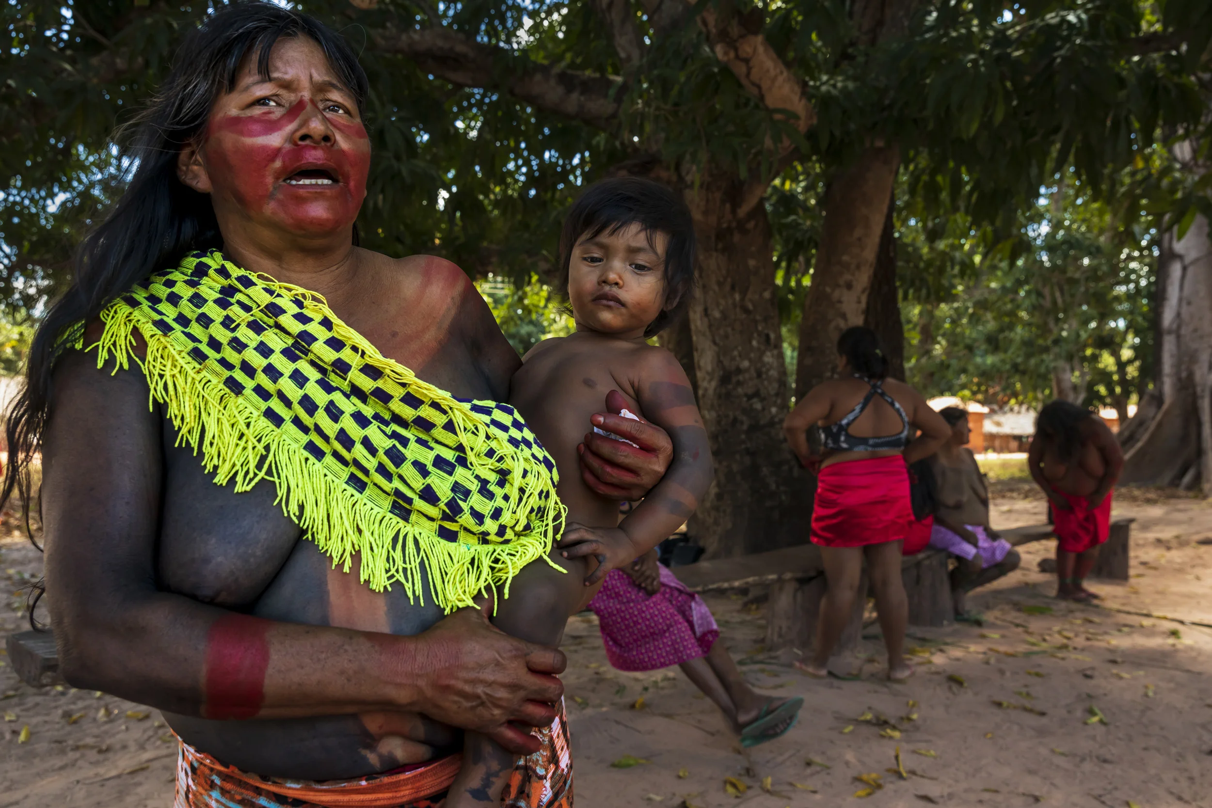 MARANHAO, BRAZIL, JUNE 2018: Indigenous people from the village of Governador prepare for a dance in the central village in the tribal area for Gaviao Indigenous people. TI Governador is the ancestral territory of the Gavião people; it encompasses 42,000 hectares of Amazon forest. Governador has been noticeably affected by deforestation, with whole areas razed of trees, dry riverbeds and frequent forest fires. People in this village say that the old days were better, their forests held more animals for hunting, more fruit and there were no problems with loggers illegally cutting their timber.
This village was running a regular forest guardian patrol but funding for indigenous NGO’s has dried up and at this time there are no patrols due to that lack of funding. 3 years ago this village confiscated logging vehicles by force which led to a confrontation with the loggers. The village was abandoned by the military police, who were supposed to protect them from the illegal loggers. The military police only returned a week later during which time the village had to defend themselves. Environmental defenders in Governador have been subjected to threats, death threats, intimidation, assault and armed attacks. Defenders reported receiving threatening anonymous calls usually after seizing a truck during one of the patrols; sometimes the callers would also issue death threats towards the defender or towards their whole village. Loggers residing in the neighboring town have intimidated and physically assaulted at least 2 indigenous leaders when they traveled to town. In one instance loggers intimidated shop owners in town so they wouldn’t sell gas to indigenous people for two weeks. To date, there seem to have been no killings of Gavião environmental defenders in retaliation for their activism.
Gavião people are ambivalent about the role of the State. Several environmental defenders have worked or continue to work with Funai, the specialised governmental agency for indig