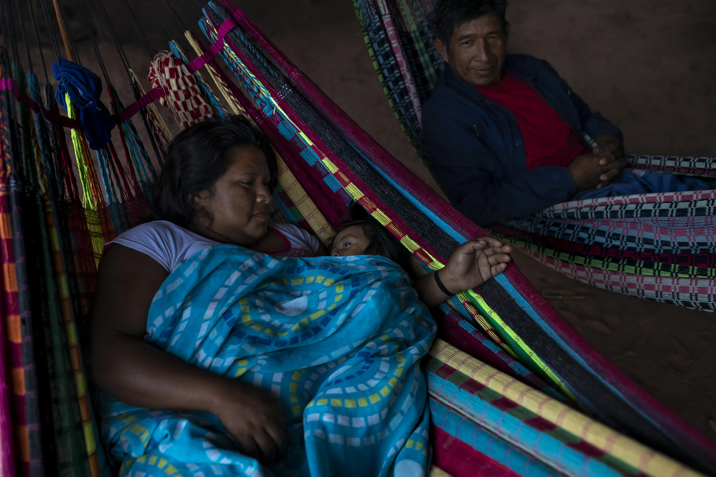 MARANHAO, BRAZIL, JUNE 2018: Early morning family scenes from the village of Governador, the central village in the tribal area for Gaviao Indigenous people. TI Governador is the ancestral territory of the Gavião people; it encompasses 42,000 hectares of Amazon forest. Governador has been noticeably affected by deforestation, with whole areas razed of trees, dry riverbeds and frequent forest fires. People in this village say that the old days were better, their forests held more animals for hunting, more fruit and there were no problems with loggers illegally cutting their timber.
This village was running a regular forest guardian patrol but funding for indigenous NGO’s has dried up and at this time there are no patrols due to that lack of funding. 3 years ago this village confiscated logging vehicles by force which led to a confrontation with the loggers. The village was abandoned by the military police, who were supposed to protect them from the illegal loggers. The military police only returned a week later during which time the village had to defend themselves. Environmental defenders in Governador have been subjected to threats, death threats, intimidation, assault and armed attacks. Defenders reported receiving threatening anonymous calls usually after seizing a truck during one of the patrols; sometimes the callers would also issue death threats towards the defender or towards their whole village. Loggers residing in the neighboring town have intimidated and physically assaulted at least 2 indigenous leaders when they traveled to town. In one instance loggers intimidated shop owners in town so they wouldn’t sell gas to indigenous people for two weeks. To date, there seem to have been no killings of Gavião environmental defenders in retaliation for their activism.
Gavião people are ambivalent about the role of the State. Several environmental defenders have worked or continue to work with Funai, the specialised governmental agency for indigenous issues