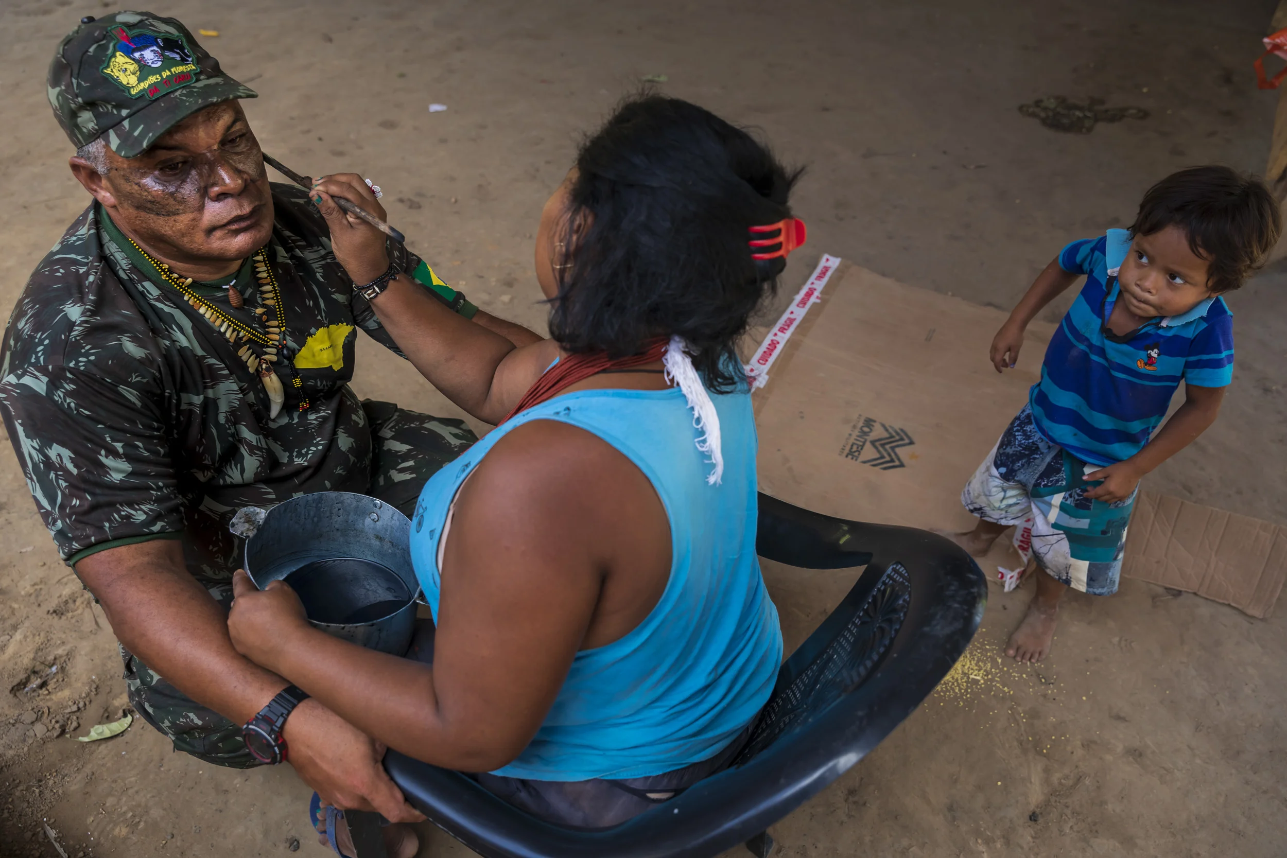 MARANHAO, BRAZIL, JUNE 2018: Chief Antonio Wilson Guajajara from the village of Macaranduba in the Karu Indigenous Territory. He is seen being painted in traditional patterns before a patrol and also on the bank of the river flowing through his territory. This village has experienced many problems with illegal loggers and have used their settlement funds from a mining dispute to create an organized patrol of forest guardians. The women of the village have learnt to fly a drone and work together with the men to reinforce these patrols. In 2013 there was much disharmony in the village but this was successfully resolved, largely thanks to pressure from the women in the village. Those who were working with illegal loggers were expelled and from that time there has been solidarity in working towards the preservation of the forest. (Picture by Brent Stirton/Getty Images for Human Rights Watch.)
