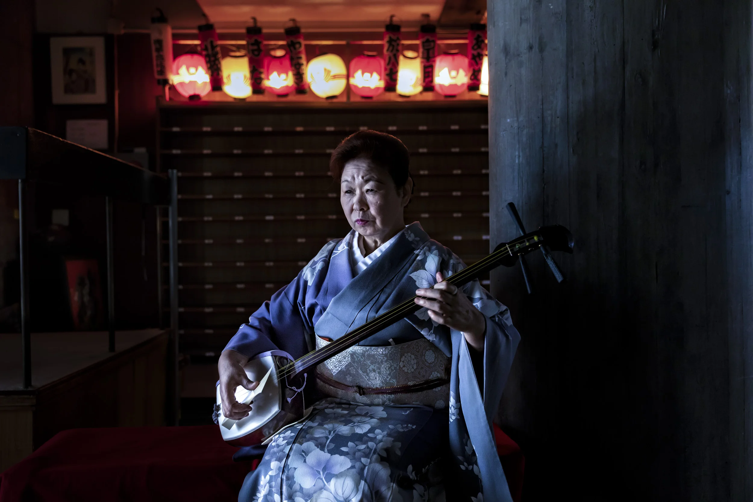 Tokyo, Japan, April 2018: A Oneisan practices with her Shamisen at the Asakusa Kenban where Geisha shows are held for clients. The bridge of the Shamisen is made of ivory and the plectrum , known as a Bachi, is also made of ivory and is said to create the best sound. The skin on the front of her Shamisen is made of cat skin and the skin at the back is made of dog skin. The instrument itself was made 15 years ago. The shamisen is a plucked stringed instrument. Its construction follows a model similar to that of a guitar or a banjo, with a neck and strings stretched across a resonating body. The neck of the shamisen is fretless and slimmer than that of a guitar or banjo. The body resembles a drum, having a hollow body that is covered front and back with skin, in the manner of a banjo. The skin used depends on the genre of music and the skill of the player. Traditionally skins were made using dog or cat skin but use of these skins gradually fell out of favor starting around 2006 due to social stigma and the decline of workers skilled in preparing these particular skins. The bachi or plectrum used to play the shamisen also differ in size, shape, and material from genre to genre. The bachi used for nagauta shamisen are made out of three possible materials, i.e. wood, plastic, or ivory. Ivory is the preferred substance and Shamisen players often believe it delivers the best sound. (Photo by Brent Stirton/Verbatim by Getty Images.)