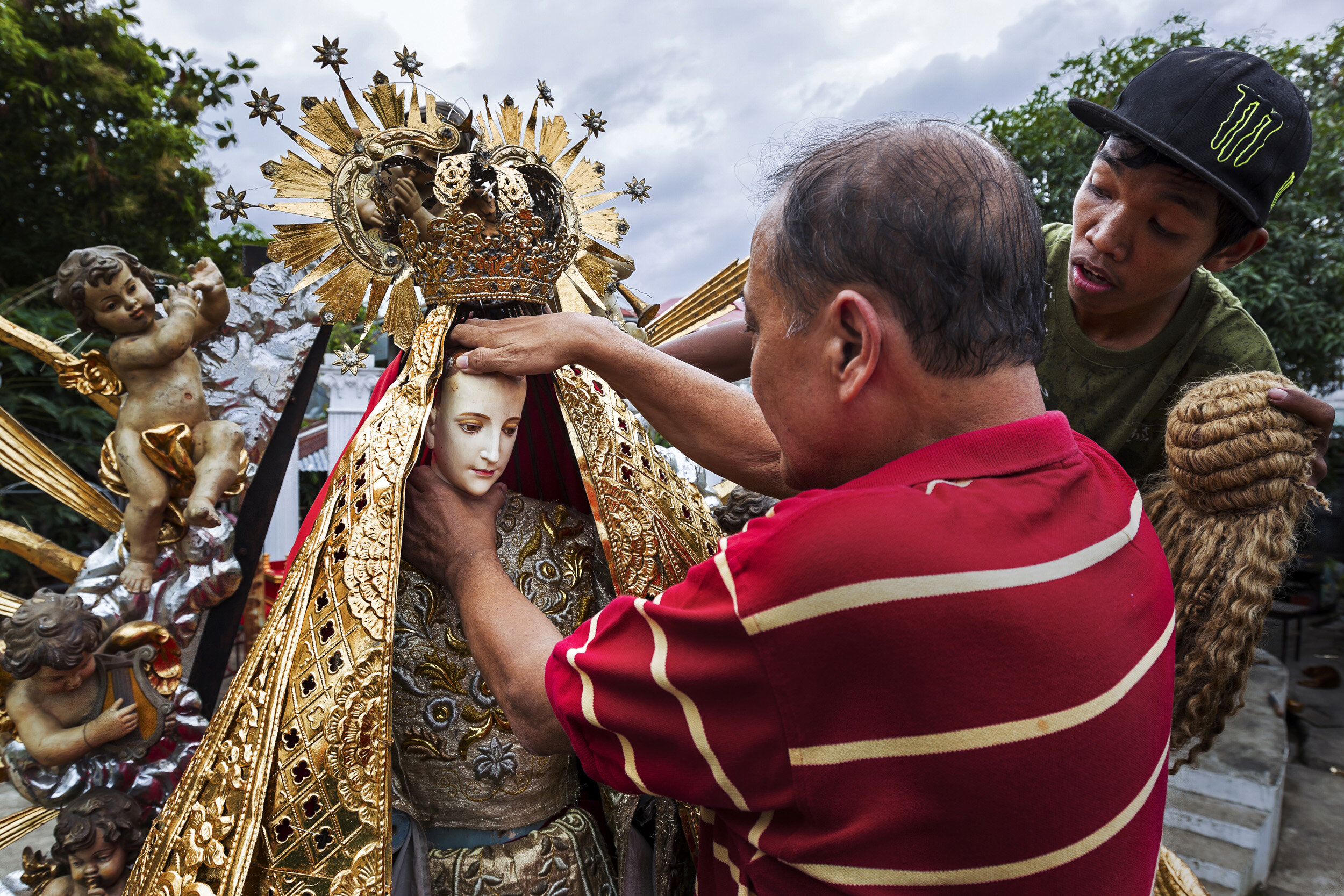 MALOLOS, PHILIPPINES, JANUARY 2012: Dez Battista, an expert on religious icons in the Philippines, prepares his " Nuestra Senora Reina del Ciela," (Our Lady of Heaven," for a religious procession in the streets of Malolos, the birthplace of the Sant