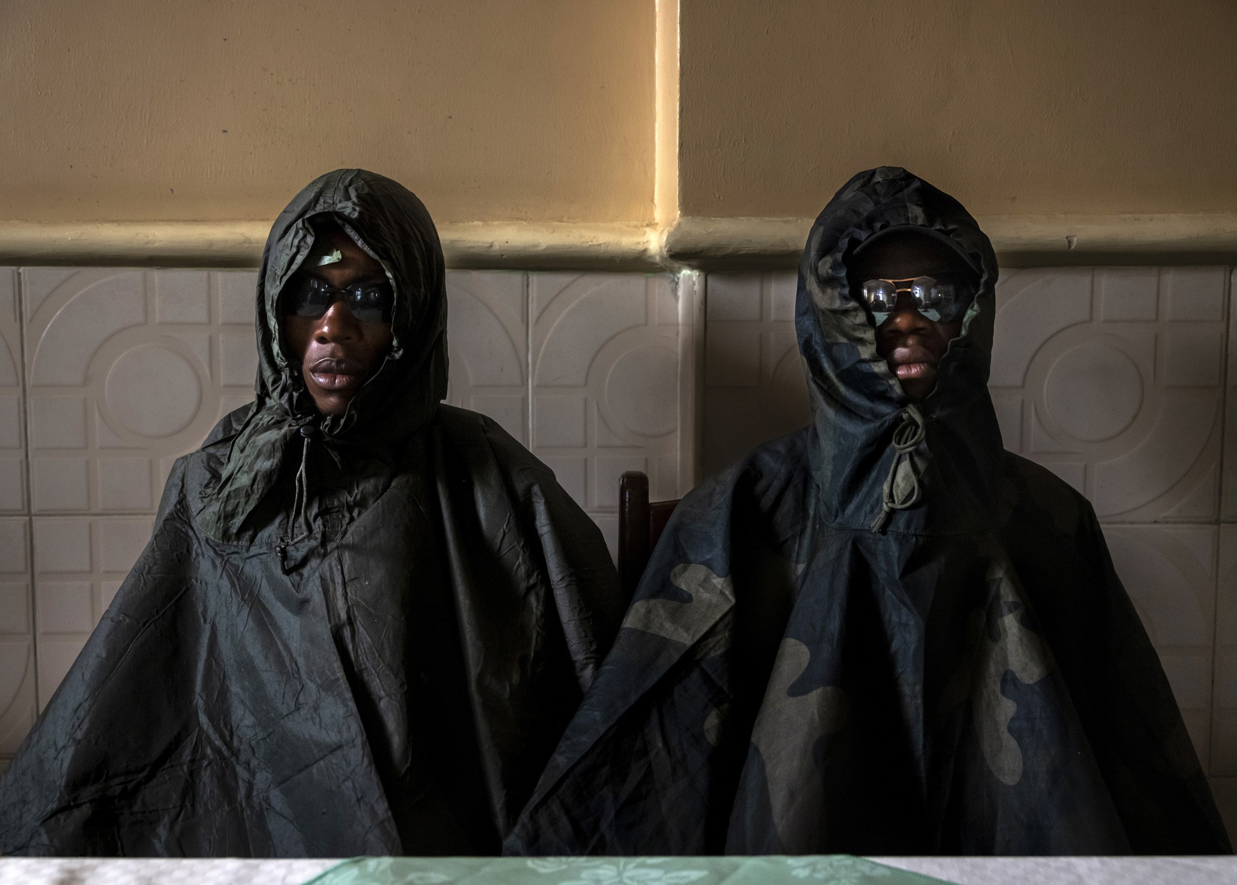 KASINDI, DEMOCRATIC REPUBLIC OF CONGO, 4 APRIL 2021: Two recently detained ADF fighters who are seen in disguise to protect their identity while they collaborate with the Congolese Army FARDC. The man on the left is Kasereka Mwinid Omar, 19, who was