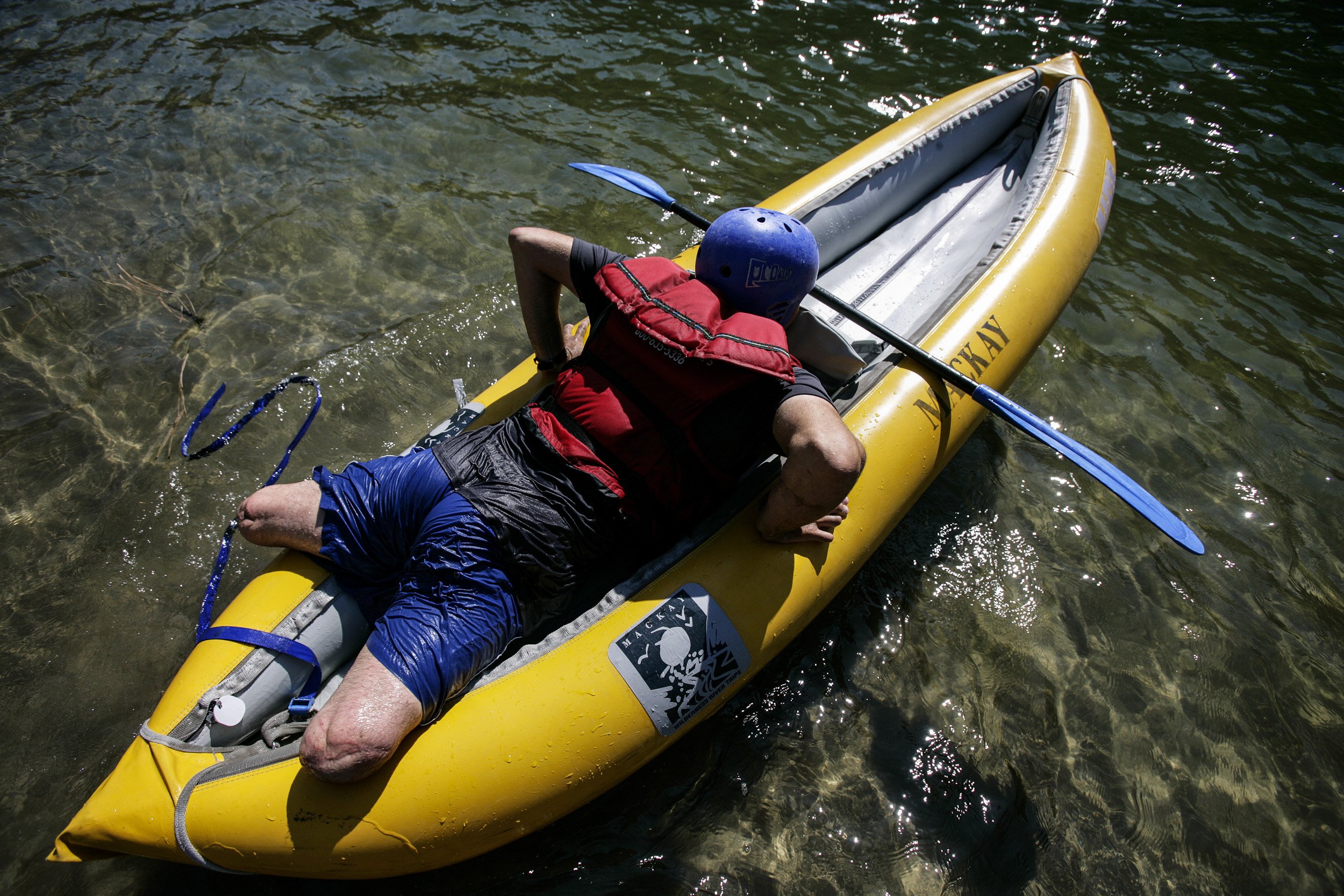 SALMON RIVER IDAHO - AUGUST 8/14 2006: Specialist Andy Soule, 25, gets into his inflable kayak at the beginning of the day on a 4 day river rafting trip on the Main Salmon River in Idaho. These images focus on a week outdoors with three disabled war
