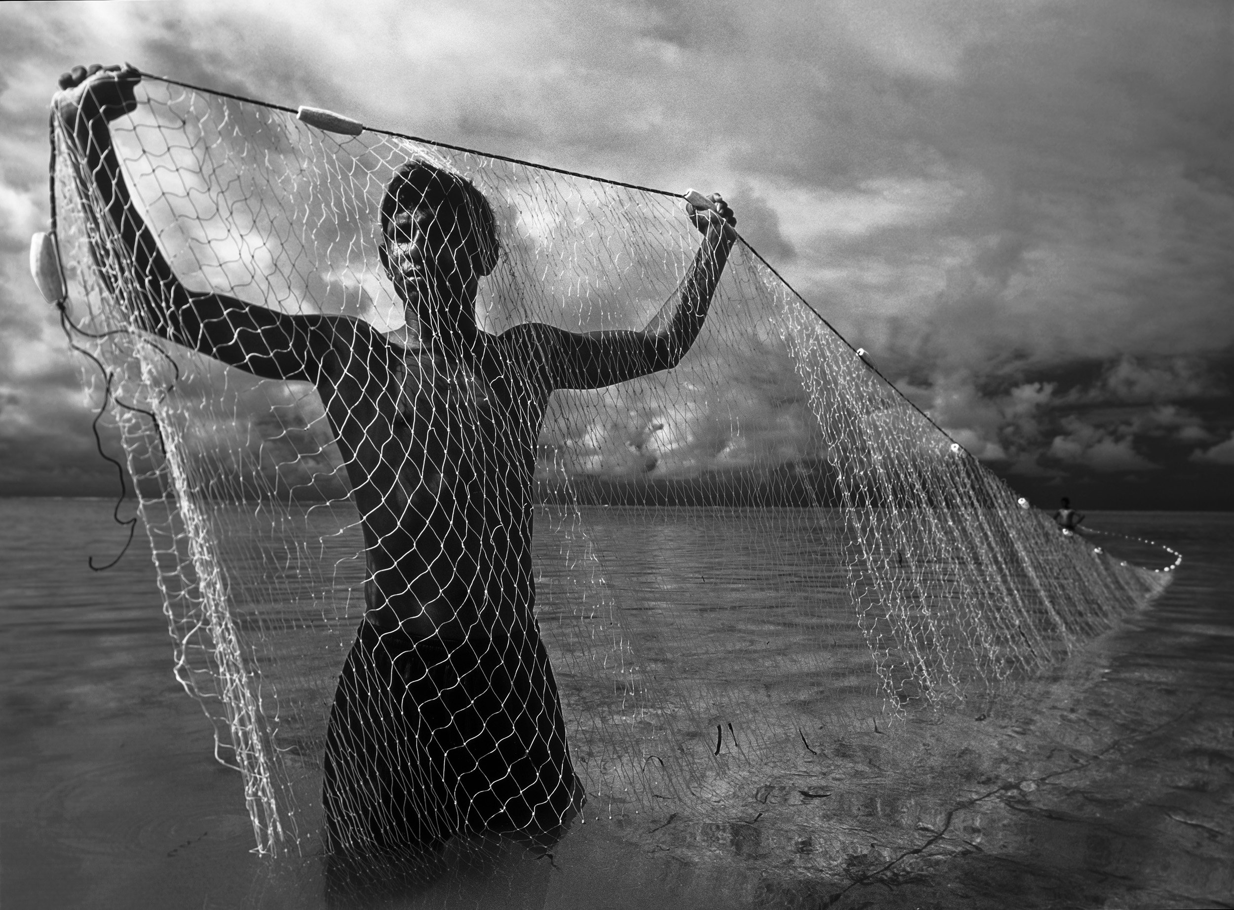 Maldives: Fishermen in the Maldives raises an empty net, they say that this used to be an abundant fishing area but global warming has killed many reefs in the Maldives and the waters now yield very little fish. This forces fisherman to travel much