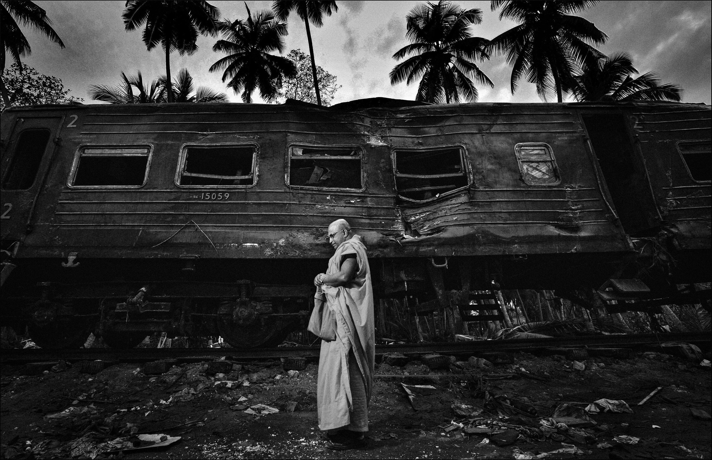 KAHAWA, SRI LANKA : The Venerable Dr. Talawe Sangharatana Thero stands in contemplation outside a train wrecked in the Asian Tsunami disaster, Kahawa, Sri Lanka. Over 800 people died in the wreck, many of whom were children. Dr Thero is one of the s