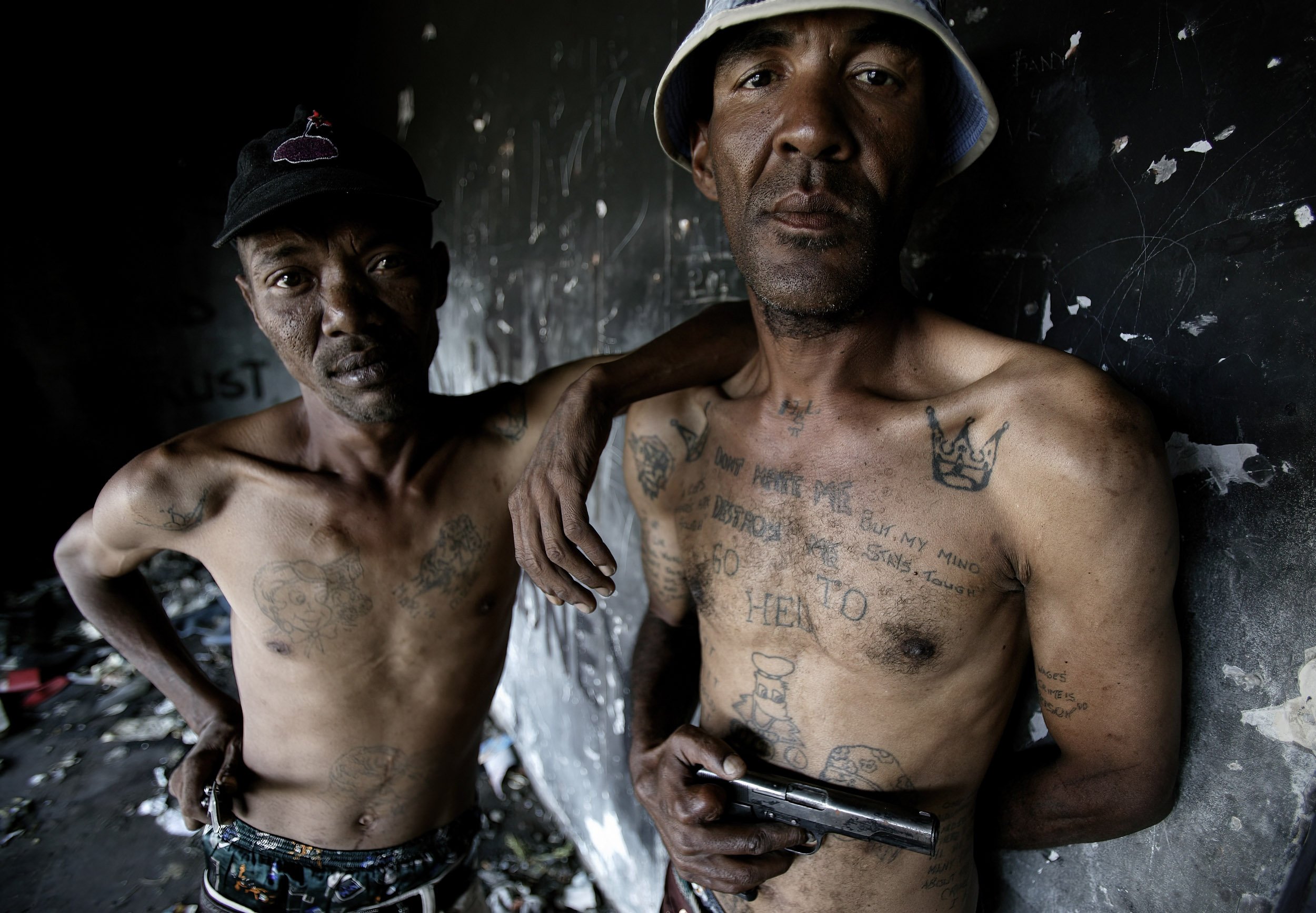 LAVENDER HILL, CAPE FLATS, SOUTH AFRICA: Two senior members of the Americans gang guard an area where there are frequent drug transactions. Both men show tattoos also connecting them to the 26’s, a numbers gang from South African prisons. These tatt
