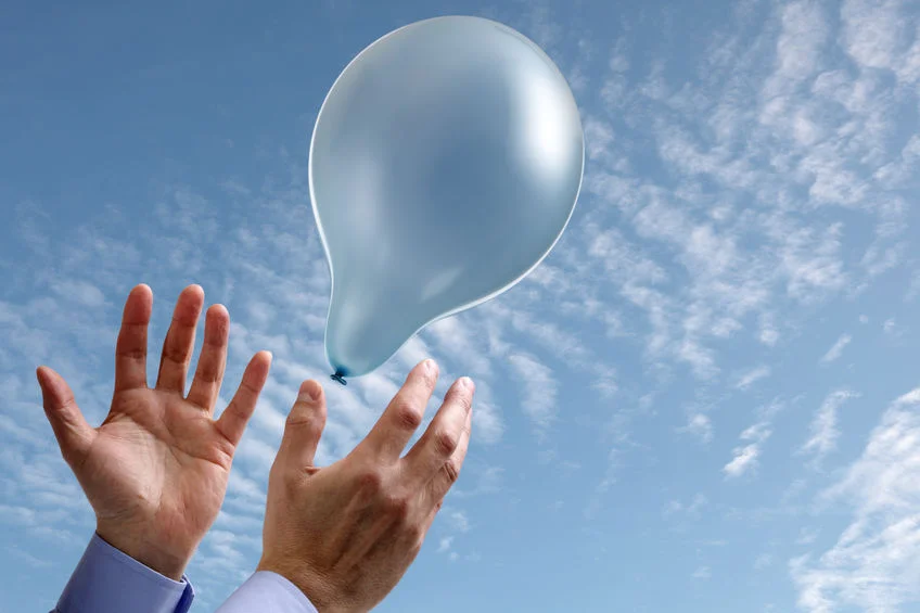 25355852 - releasing a balloon into the air concept for dreams and aspirations with copy space on the balloon and sky