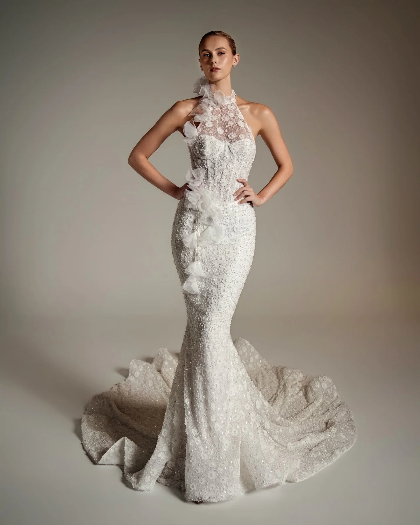 V A L E R I E 🤍 Modern romance, beautifully redefined.

A sculpted halter neckline, shimmering beadwork, and delicate 3D florals that bloom and float with every step. Finished with a sweeping train, Valerie is made for the bride who loves elegance w