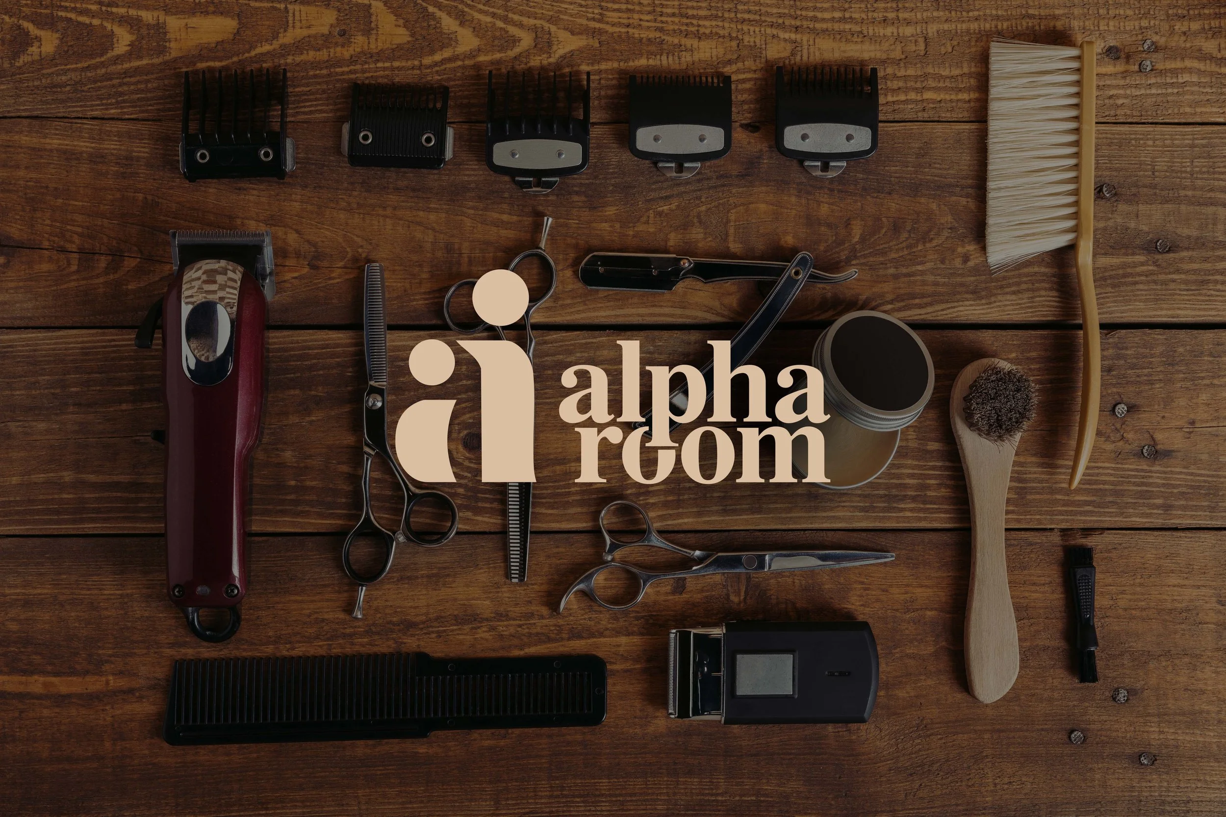 Barber tools including clippers, scissors, combs, brushes, and styling products arranged on a wooden surface.
