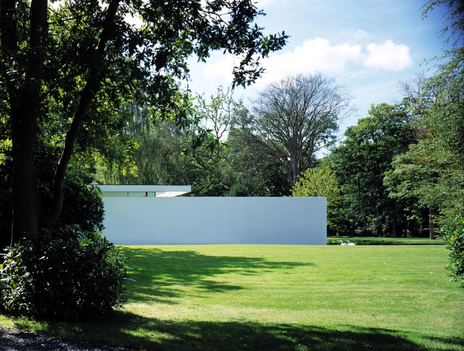 The sculptural north facade ,with its clerestory, floating roof plane and pure white wall extending into the lake is reminiscent of a sleek marine craft.