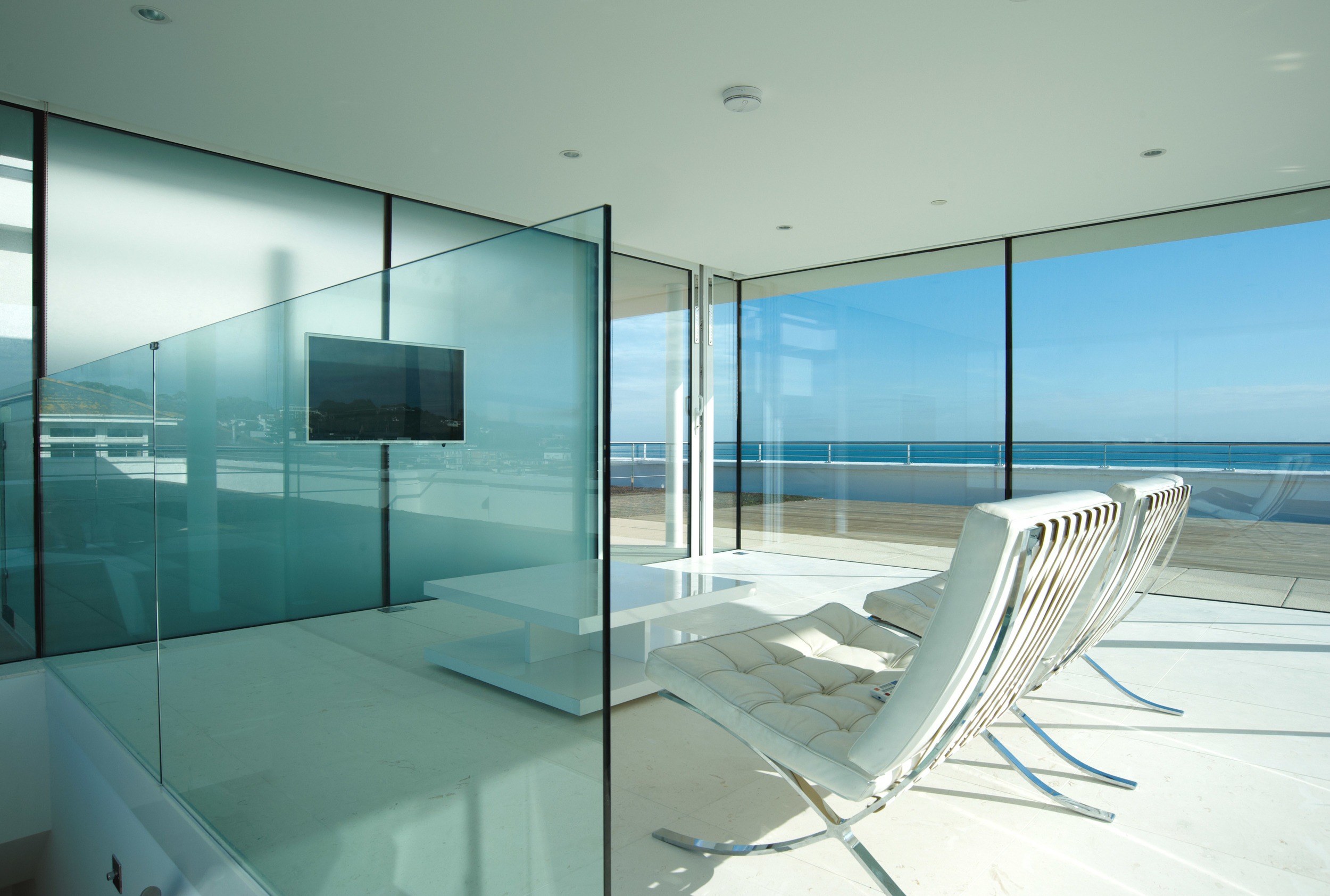 The interior of the sunroom over Flat 9 and shows the flat sreen TV mounted dirctely on the glass exterior wall.