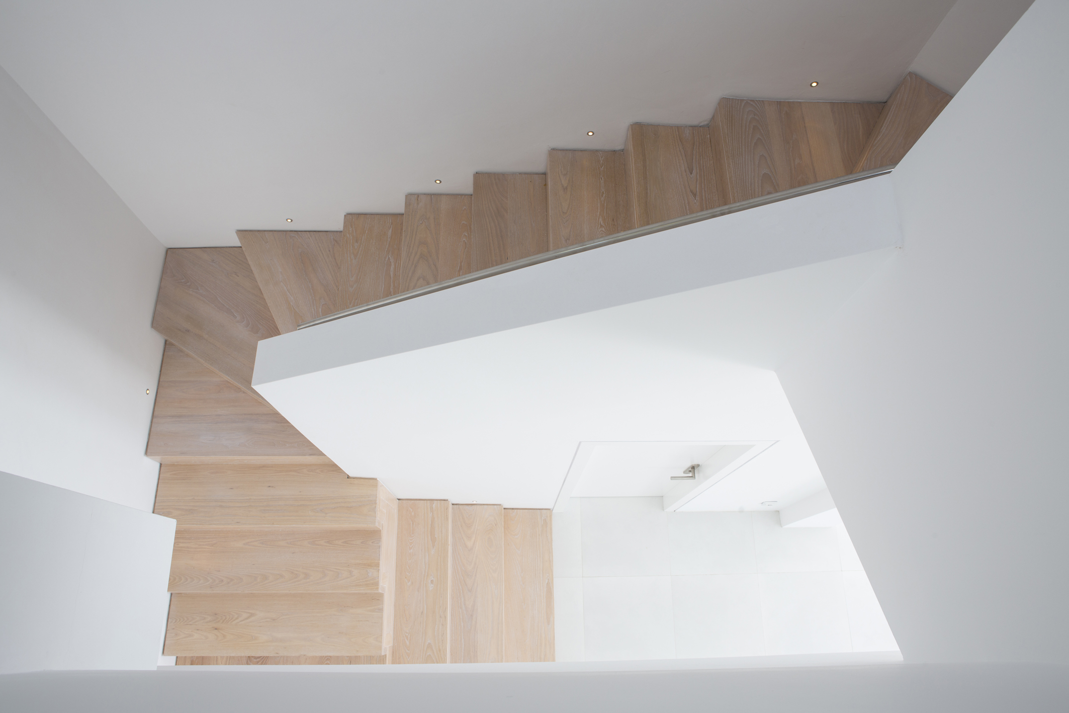 The original main staircase had terracotta floor tiles and a painted metal balustrade. The new staircase is completely revised with solid oak treads and a central spine wall with stainless steel handrail and mini built in LED