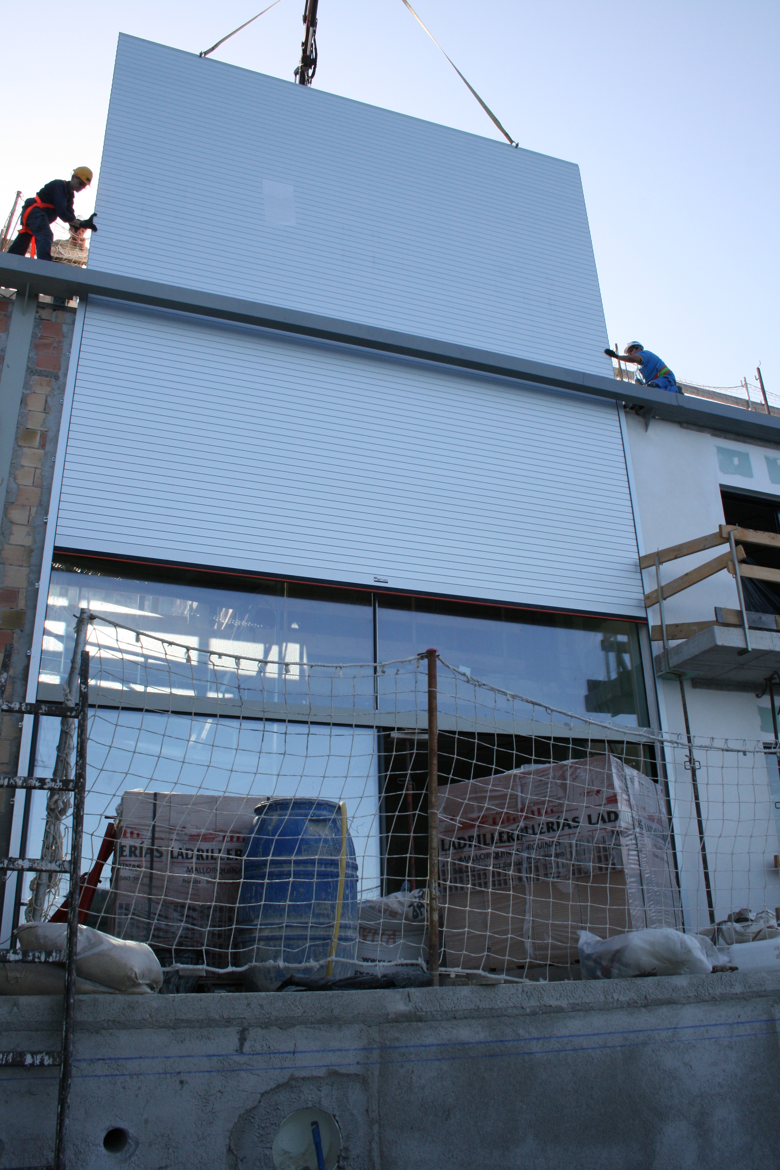 Installing the single piece 6.5 m square electric roller shutter that protects the main facade from sun and wind .