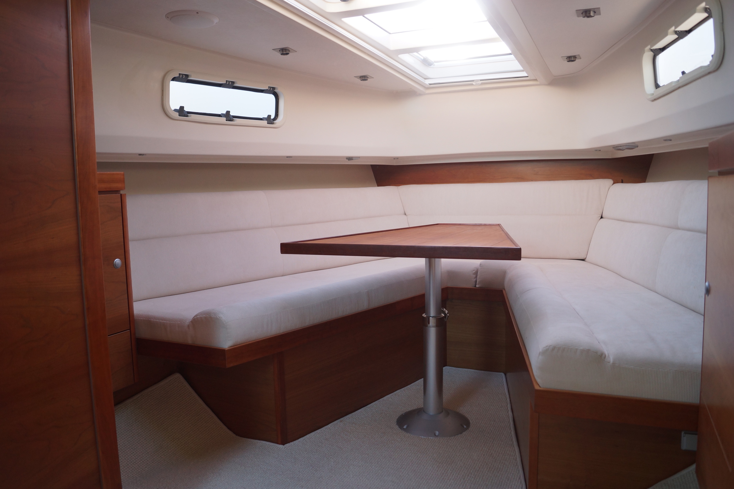 Remodeled interior with 'V' berth design and new central table using mattching Fjord fabrics and veneers.