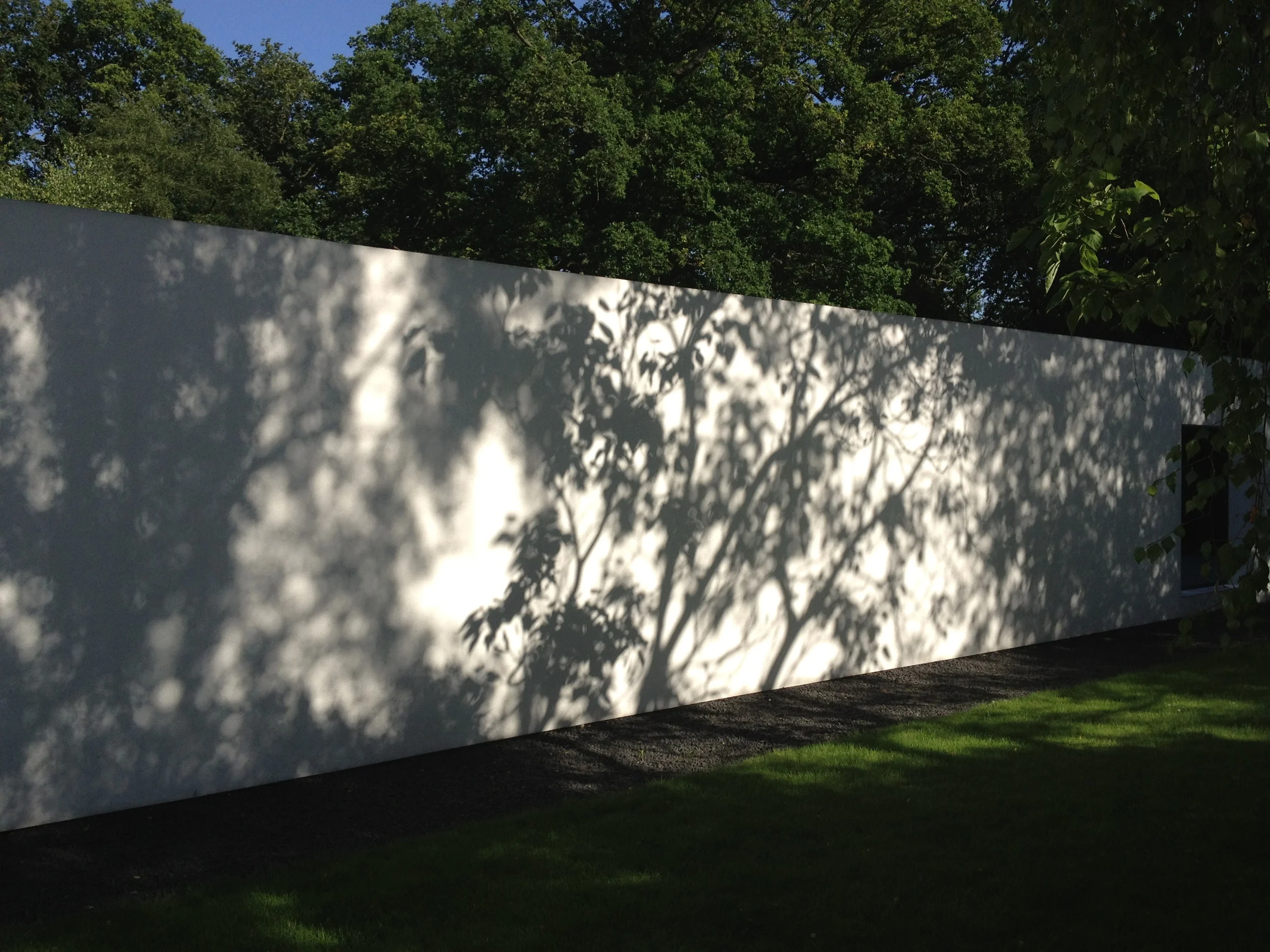 Shadows cast on long wall to garden wing .