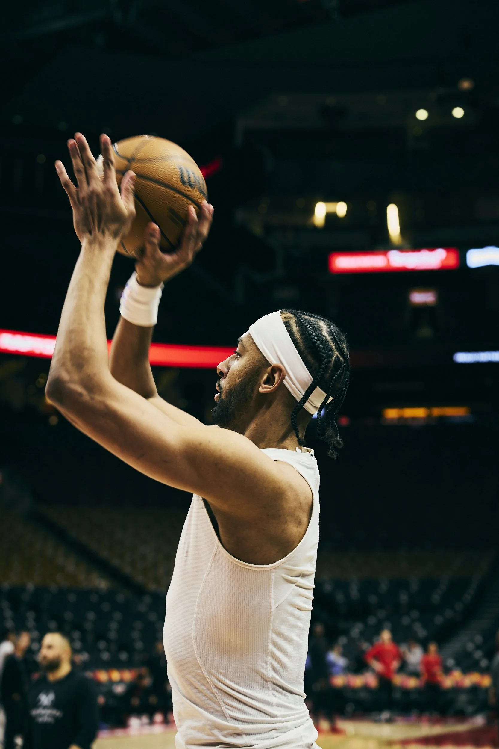 A basketball player in a white jersey preparing to take a shot during a game.
