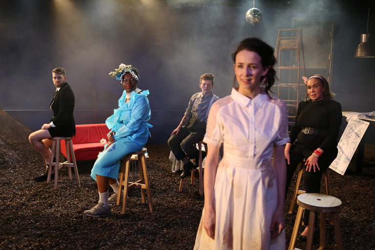  Left to right: Tommy Heleringer, Julienne "Mizz June" Brown, Jess Barbagallo, Kristen Sieh, Cecilia Gentili. Kristen as Emily in a white dress stands facing the audience in the foreground. Everyone else is one stools looking over their shoulders at 