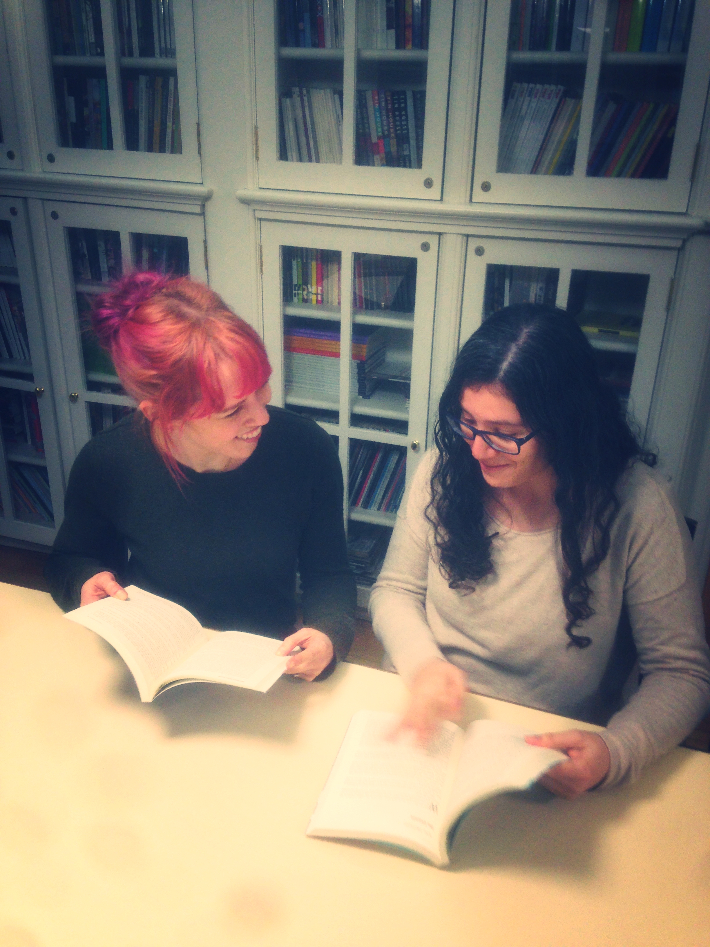 Assistant Fiction Editor Alyssa diPierro (LEFT) and Fiction Editor Bruna Dantas Lobato (RIGHT) pretend to flip through old Washington Square Review journals at the Creative Writing House.