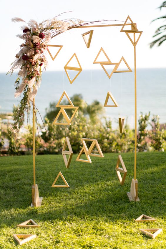 13-an-arch-with-wooden-triangles-hanging-and-bold-flowers-on-the-corner.jpg