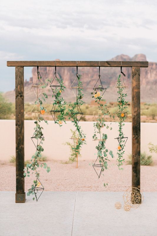 25-geometric-desert-wedding-arbor-with-hanging-greenery-and-color-coordinated-flowers-scattered-throughout.jpg