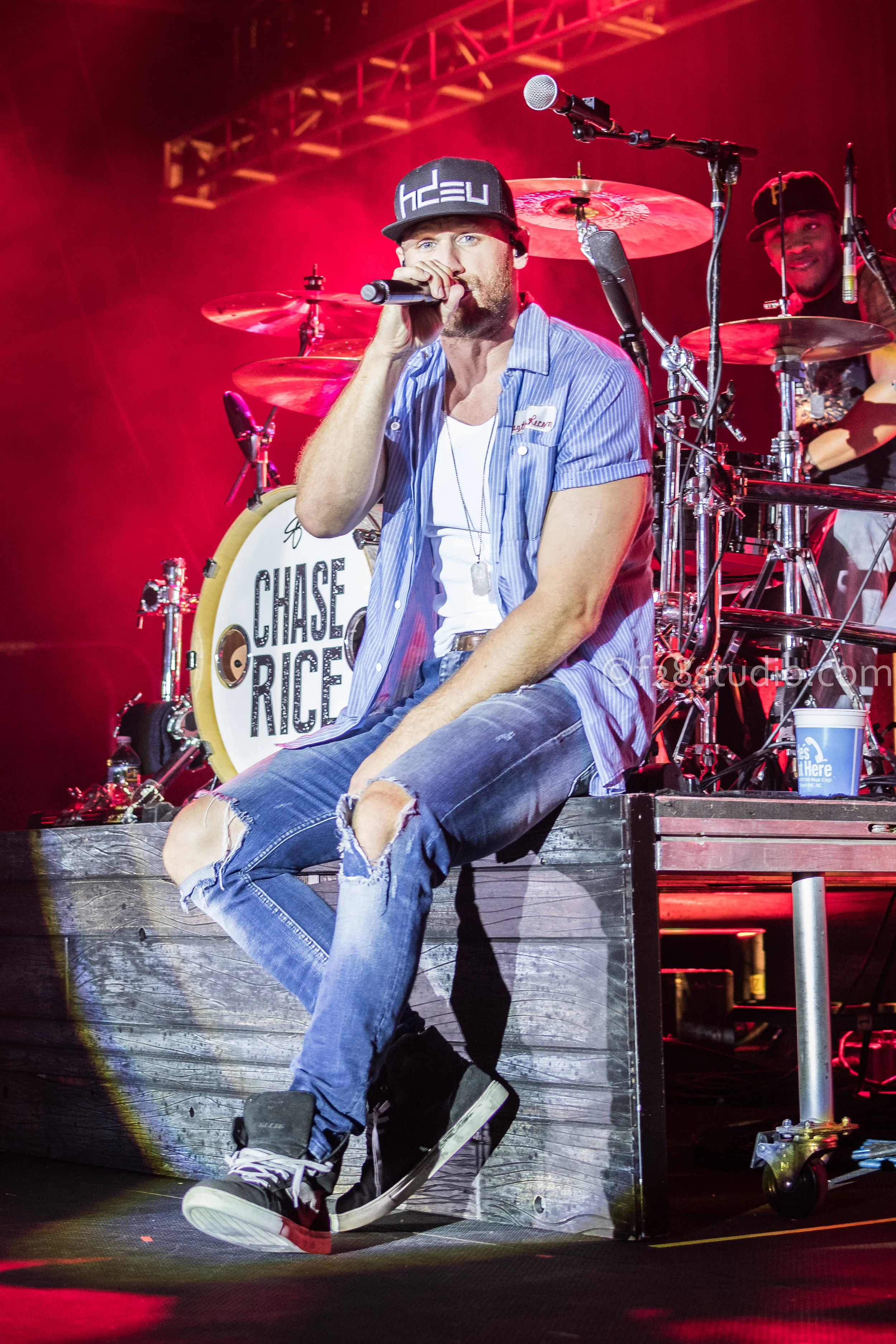 Chase Rice sitting down during one of his songs. 