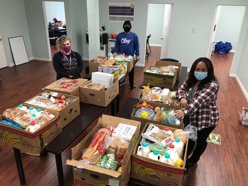 ORANGE COUNTY AOT STAFF MEMBERS SMILING THROUGH THEIR MASKS AFTER RECEIVING THE GENEROUS FOOD DONATION.