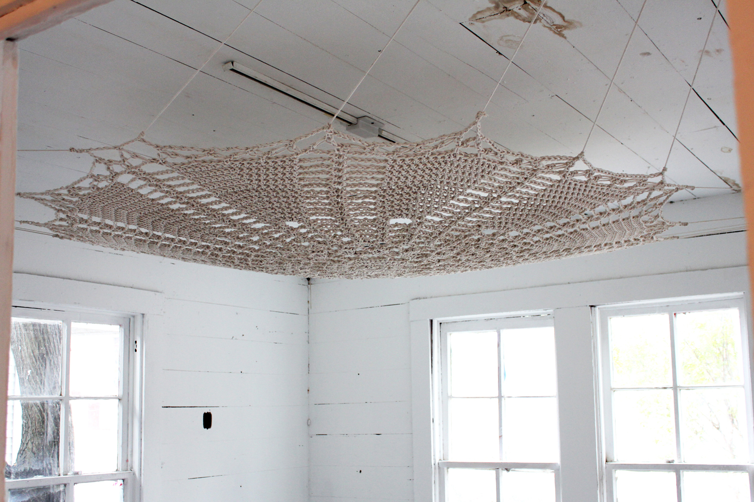 Embellished with the charged materials of Hoodoo and Germanic folk belief—horseshoes, scissors and the railroad spikes that nail this crocheted work into the corners—the oversized doilies become fetishes to ward away or trap negative influences.