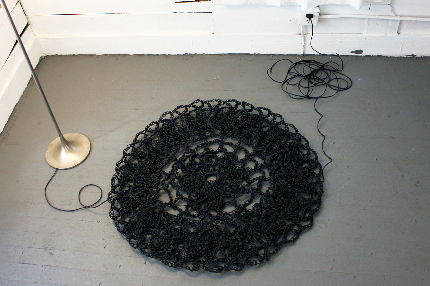 Crocheted from over 1500 feet of electrical wire, the doily powers the light in the room.