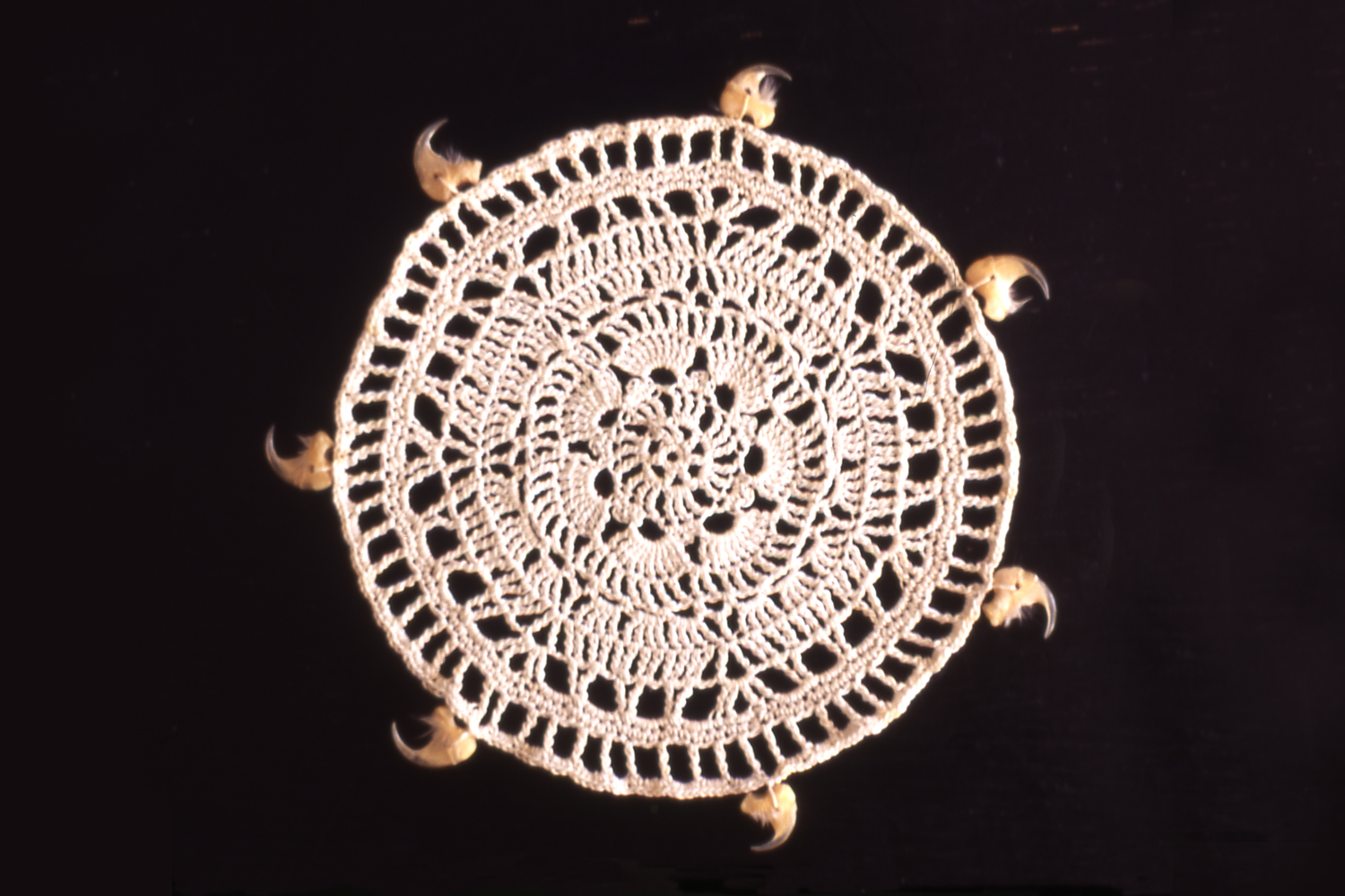 NAIL FETISH subverts a domestic icon of decoration and protection, a crocheted doily, with the addition of cat claws, a reference to the witches’ familiar.
