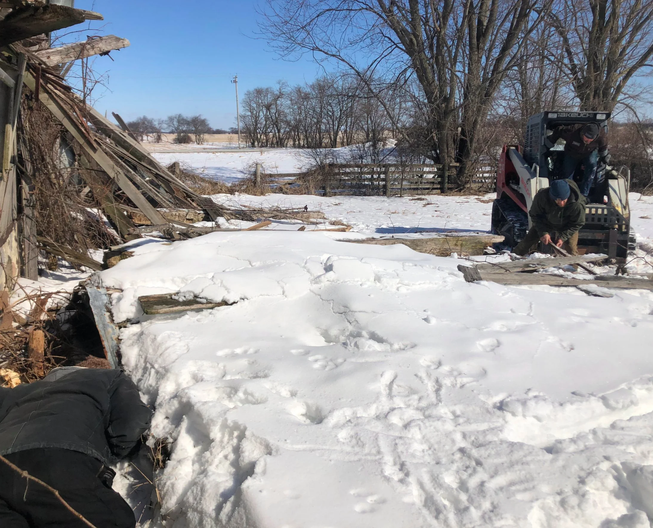 Adam spies Cooper trapped under the debris. Seth and Kalen using the skid loader to lift up the fallen roof.