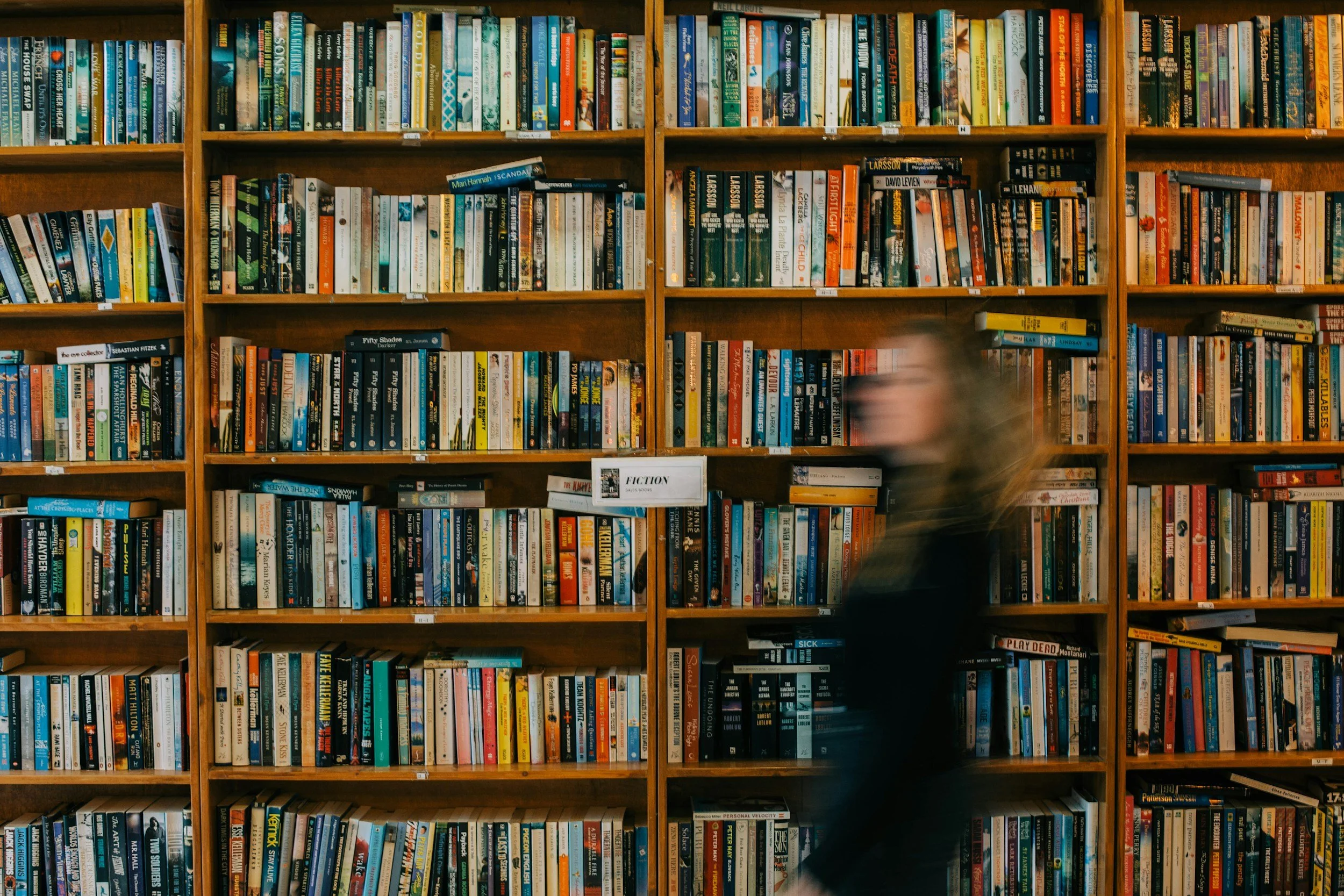 Bookshelves filled with a variety of books in a library or bookstore.