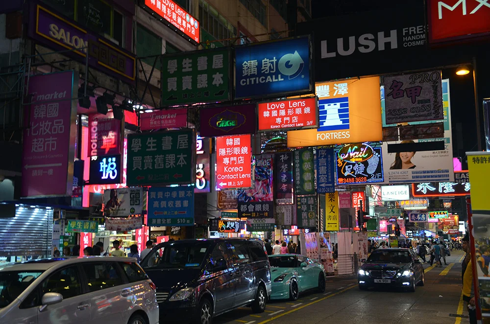 Fancy cars and lots of signs occupy the streets of Hong Kong.