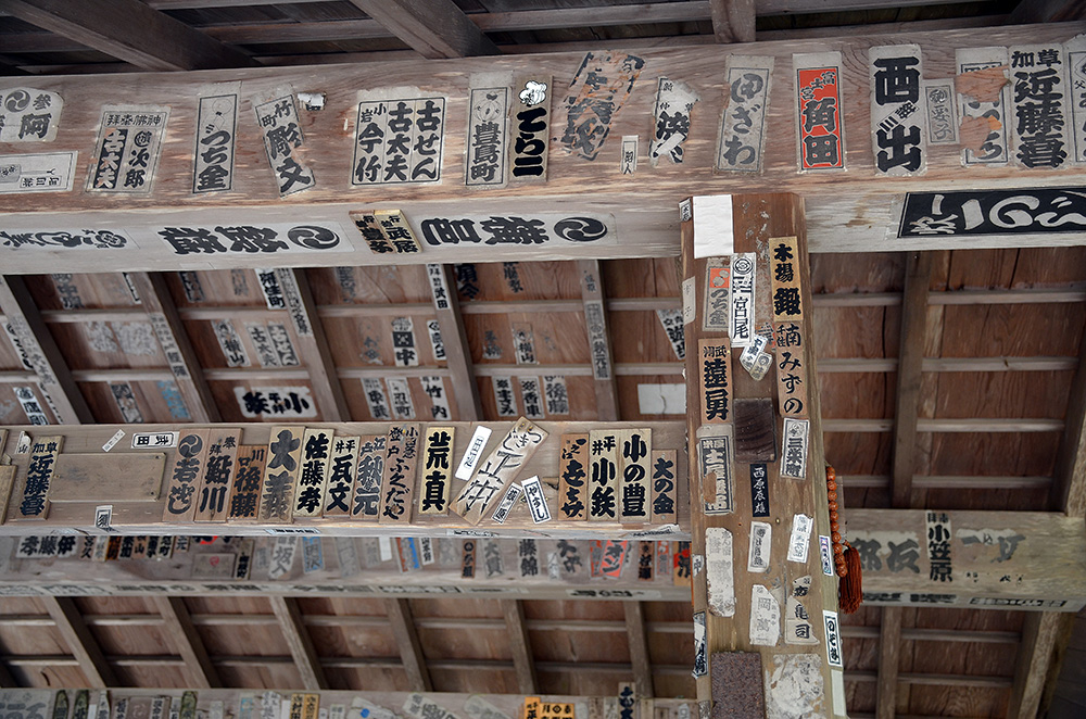 Prayer stickers adorn a well near a temple entrance.