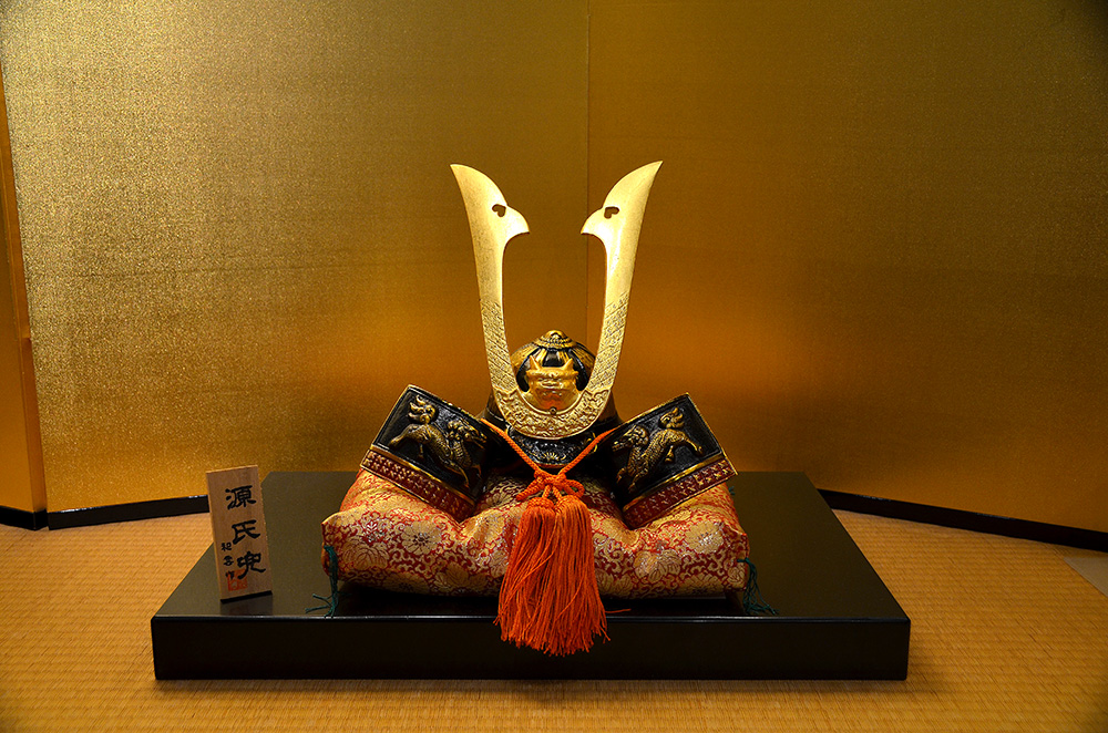 A gold leaf wall surrounds a gold leaf helmet. Lots and lots of gold everywhere.