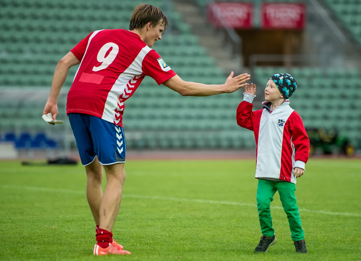 Birger Rasmussen, spiss på A-laget, hilser på en ung LYN-supporter etter en seier på Bislett, høsten 2015. Foto: Lars Opstad/Lyn Fotball.