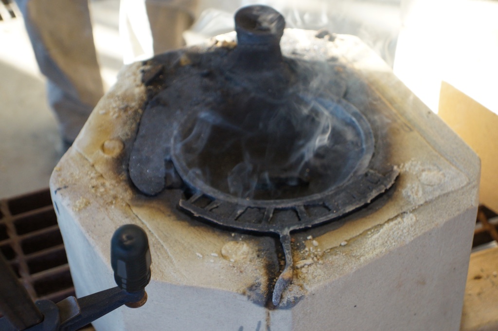1. Just poured first the half of an OiB and opened the sand mold whilst it’s still smoking. The lines and knob you see are the channels the liquid bronze pours into to get to the actual center of the mold where the sculpture is formed.