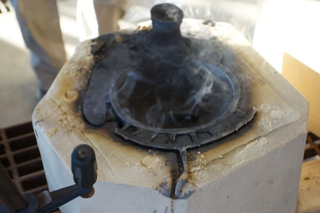 1. Just poured first the half of an OiB and opened the sand mold whilst it’s still smoking. The lines and knob you see are the channels the liquid bronze pours into to get to the actual center of the mold where the sculpture is formed.